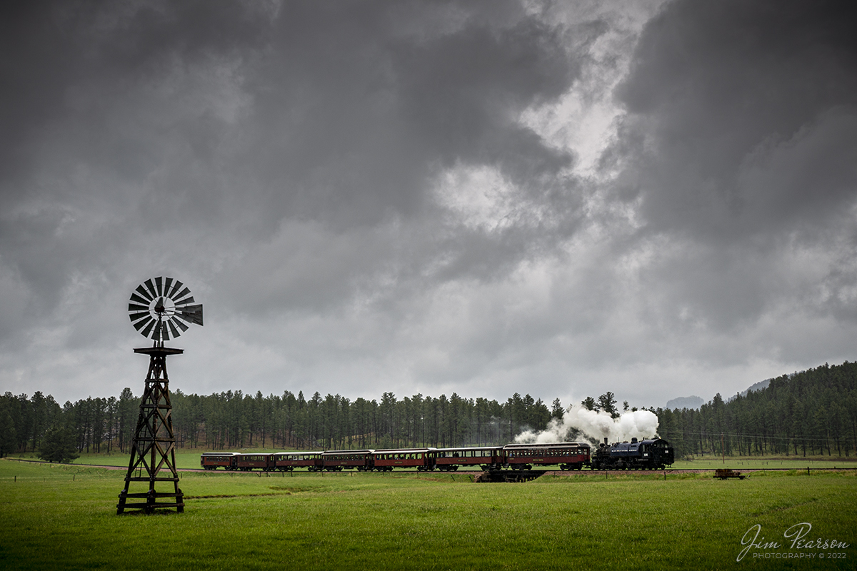 The Black Hills Central Railroad Locomotive Passes An Old Windmill