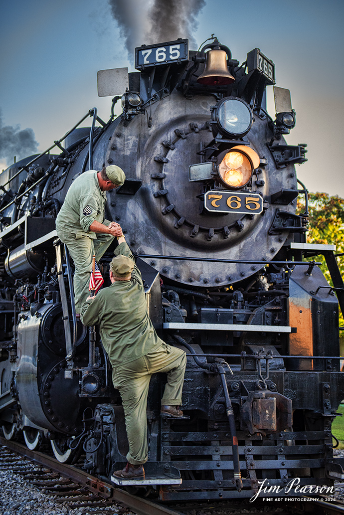 Military reenactors Ken Hoelscher helps Tyler Kostyla up onto the nose of NKP 765 during the evening/night photo shoot at Pleasant Lake, IN, on August 31st, 2024, during the Rolling Victory Weekend. During World War II there were military crews that ran and maintained this locomotive, from what I’m told.

According to their website: Rolling Victory was a three-day living history event celebrating American military, railroad, and home front history featuring vintage train rides, World War II reenactors, battles, a big band orchestra, and an immersive and educational experience for all ages in Pleasant Lake, Indiana.

Tech Info: Nikon D810, RAW, Nikon 24-70 @ 48mm, f/2.8, 1/640, ISO 450.

#railroad #railroads #train, #trains #railway #railway #steamtrains #railtransport #railroadengines #picturesoftrains #picturesofrailways #besttrainphotograph #bestphoto #photographyoftrains #bestsoldpicture #JimPearsonPhotography #steamtrains #nkp765 #passengertrains