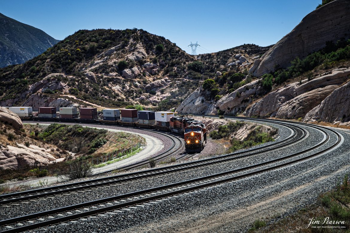 BNSF 7902 leads an eastbound intermodal up the Cajon Pass at the location known as Sullivan's Curve, on September 27th, 2011, on the BNSF Cajon Subdivision.

According to what I find on the web: Railfanning in the Cajon Pass Sullivan's Curve Sullivan's Curve is a specific section of the railroad through Cajon Pass that features a sharp curve, providing a challenging and visually striking portion of the route. The curve is named after Herbert S. Sullivan, who made promotional photos at this curve for Santa Fe in the 1940s and 50s.

Tech Info: Nikon D700, RAW, Sigma 24-70 @ 62mm, f/11, 1/500, ISO 640.

#photographyoftrains #trainphotography #JimPearsonPhotography #trendingphoto #bnsf