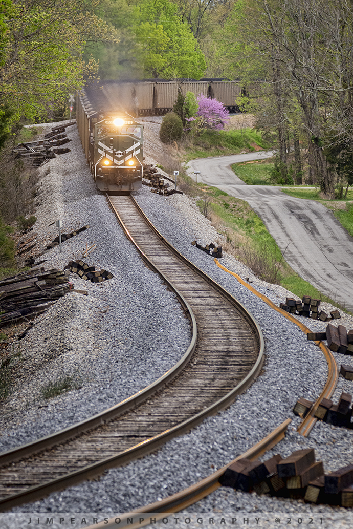 Paducah and Louisville LG1 northbound at Summit, Kentucky

I love a spot that allows for good use of leading lines in a photograph, such as this shot! Here, Paducah and Louisville 4516 and 2012 lead loaded coal train LG1 (Louisville Gas & Electric) as they make their way through Summit, Kentucky on April 14th, 2021 on the way to the LG power plant at Louisville, Ky. 

Judging from the right of way, maintenance of way crews are preparing to replace ties and rails in the curves here, which is a never-ending job on the railroad!

From Wikipedia: The Paducah & Louisville Railway (reporting mark PAL) is a Class II railroad that operates freight service between Paducah and Louisville, Kentucky. The line is located entirely within the Commonwealth of Kentucky.

The 270-mile line was purchased from Illinois Central Gulf Railroad in August 1986. The 223-mile main route runs between Paducah and Louisville with branch lines from Paducah to Kevil and Mayfield, Kentucky, and another from Cecilia to Elizabethtown, Kentucky. The PAL interchanges with Burlington Northern Santa Fe (BNSF) and Canadian National (CN), formerly Illinois Central Railroad, in Paducah. In Madisonville, the line interchanges with CSX Transportation (CSXT).

In Louisville, the line interchanges with the Indiana Railroad (INRD), CSX Transportation (CSXT) and Norfolk Southern (NS). Class III line connections are at Princeton with the Fredonia Valley Railroad (FVRR) and at Louisville with the Louisville and Indiana Railroad (LIRC). The line today carries over 200,000 carloads of traffic on a CTC-controlled mainline with welded rail and even a section of double track nearly 20 miles long between Paducah and just east of Calvert City. This is a huge improvement from the little amount of traffic and poor condition the line was in by the time the ICG had sold it.

Today it is a big regional class II railroad connecting with four class I railroads (listed above), as well as the three shortline connections it makes which are also listed above. It has 270 route-miles of track, of which 233 miles are its mainline running between its namesake towns of Paducah and Louisville, as well as branch lines to Mayfield, Kevil, and Elizabethtown. The railroad serves "many chemical plants and other manufacturing companies, several coal mines, numerous clay and stone quarries, lumber and propane distributors, farm [including a few large grain elevators] and mine equipment suppliers, warehouses, transloads, bulk terminals, riverports, and one military base."

The parent company of the PAL, P&L Transportation, also operates the Evansville Western Railway and the Appalachian and Ohio Railroad.

Tech Info: Nikon D800, RAW, Sigma 150-600mm @ 290mm, f/7.6, 1/640, ISO 1800.