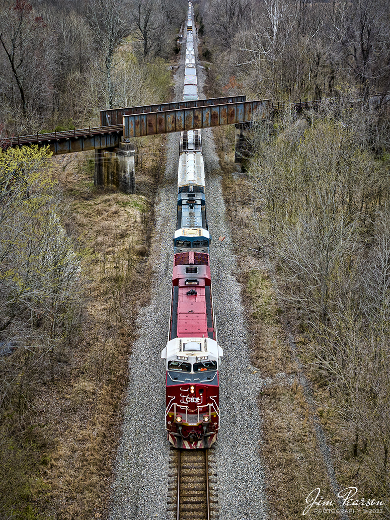 Northbound CSX M648 passes under the Paducah and Louisville Railway at Monarch at Madisonville, Kentucky with the CSXT 911, Honoring First Responders locomotive leading, on the Henderson Subdivision on March 9th, 2023.

CSXT 911 is painted in vibrant red with white and gold striped accents along with the logo of program partners First Responders Childrens Foundation and Operation Gratitude. It also features generic police, fire and emergency medical services logos.

Tech Info: DJI Mavic 3 Classic Drone, RAW, 24mm, f/2.8, 1/1000, ISO 170.

#trainphotography #railroadphotography #trains #railways #dronephotography #trainphotographer #railroadphotographer #jimpearsonphotography #kentuckytrains #csx #csxrailway #csxhendersonsubdivision #barnsely #mavic3classic #drones #trainsfromtheair #trainsfromadrone