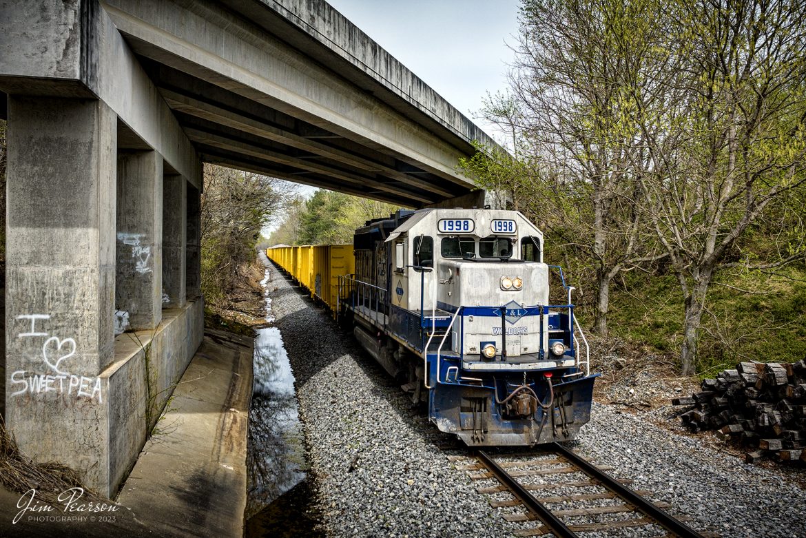 Paducah and Louisville Railway 1998, painted in University of Kentucky colors to honor their 1988 NCAA win, passes under the US 70 West overpass with a ballast train as they head south at Richland, Kentucky on April 7th, 2023.

According to Wikipedia: The Paducah & Louisville Railway (reporting mark PAL) is a Class II railroad that operates freight service between Paducah and Louisville, Kentucky. The line is located entirely within the Commonwealth of Kentucky.

The 270-mile (430 km) line was purchased from Illinois Central Gulf Railroad in August 1986. The 223-mile (359 km) main route runs between Paducah and Louisville with branch lines from Paducah to Kevil and Mayfield, Kentucky, and another from Cecilia to Elizabethtown, Kentucky. The PAL interchanges with Burlington Northern Santa Fe (BNSF) and Canadian National (CN), formerly Illinois Central Railroad, in Paducah. In Madisonville, the line interchanges with CSX Transportation (CSXT).

Tech Info: DJI Mavic 3 Classic Drone, RAW, 24mm, f/2.8, 1/1600, ISO 150.

#trainphotography #railroadphotography #trains #railways #dronephotography #trainphotographer #railroadphotographer #jimpearsonphotography #kentuckytrains #csx #csxrailway #HopkinsvilleKy #mavic3classic #drones #trainsfromtheair #trainsfromadrone #paducahandlouisvillerailway, #pal