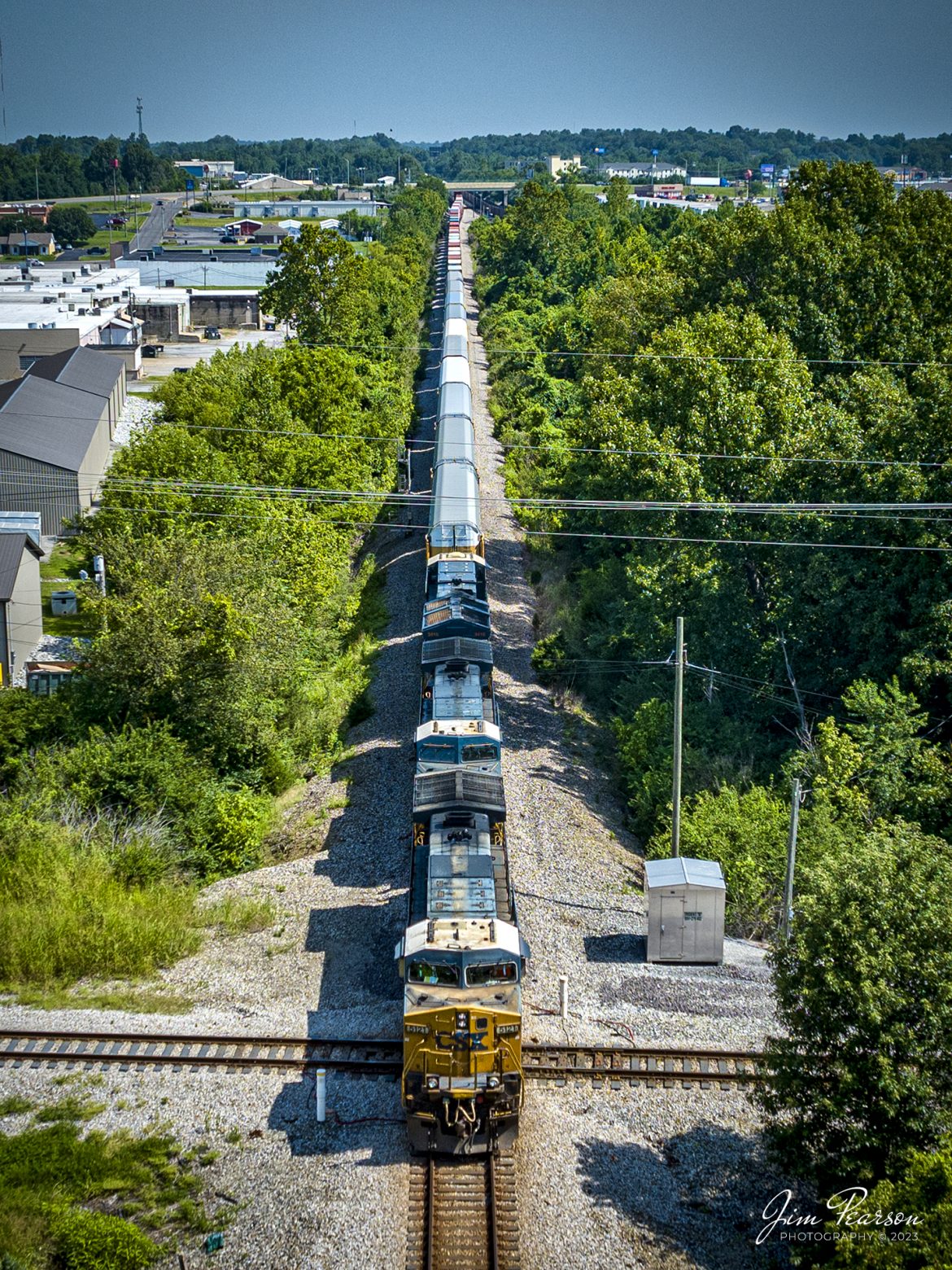 CSXT 5121 leads I025 across the Trident Diamond at Madisonville, Kentucky on July 28th, 2023, as it heads south with one of the four hot intermodals that run up and down the Henderson Subdivision.

The track to the left is the CSX Morganfield Branch where a daily local runs along with coal trains headed to and from Warrior Coal loop, just west of Madisonville. The track to the right heads into Atkinson Yard here in Madisonville.

Tech Info: DJI Mavic 3 Classic Drone, RAW, 24mm, f/2.8, 1/1600, ISO 120.

#trainphotography #railroadphotography #trains #railways #dronephotography #trainphotographer #railroadphotographer #jimpearsonphotography #TennesseeTrains #csx #csxrailway #AdamsTN #mavic3classic #drones #trainsfromtheair #trainsfromadrone #csxhendersonsubdivision #csxtrains #railtrain