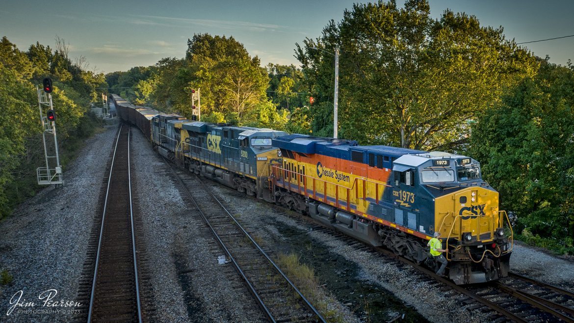 On August 12th, 2013, Conductor Nick Jochim climbs aboard CSX Heritage series locomotive 1973, the Chessie System unit, after throwing several switches to align his empty coal train E002, into the south end of Atkison Yard at Madisonville, Ky on the Henderson Subdivision. 

According to Wikipedia: The three railroads that would make up the Chessie System had been closely related since the 1960s. C&O had acquired controlling interest in B&O in 1962, and the two had jointly controlled WM since 1967.

Chessie System, Inc. was a holding company that owned the Chesapeake and Ohio Railway (C&O), the Baltimore and Ohio Railroad (B&O), the Western Maryland Railway (WM), and Baltimore and Ohio Chicago Terminal Railroad (B&OCT). Trains operated under the Chessie name from 1973 to 1987.

On November 1, 1980, Chessie System merged with Seaboard Coast Line Industries to form CSX Corporation. Initially, the three Chessie System railroads continued to operate separately, even after Seaboard's six Family Lines System railroads were merged into the Seaboard System Railroad on December 29, 1982. That began to change in 1983, when the WM was merged into the B&O. The Chessie image continued to be applied to new and re-painted equipment until July 1, 1986, when CSXT introduced its own paint scheme. In April 1987, the B&O was merged into the C&O. In August 1987, C&O merged into CSX Transportation, a 1986 renaming of the Seaboard System Railroad, and the Chessie System name was retired.

Tech Info: DJI Mavic 3 Classic Drone, RAW, 24mm, f/2.8, 1/320, ISO 420.

#trainphotography #railroadphotography #trains #railways #dronephotography #trainphotographer #railroadphotographer #jimpearsonphotography #trains #csxt #mavic3classic #drones #trainsfromtheair #trainsfromadrone #CSXHeritageUnits