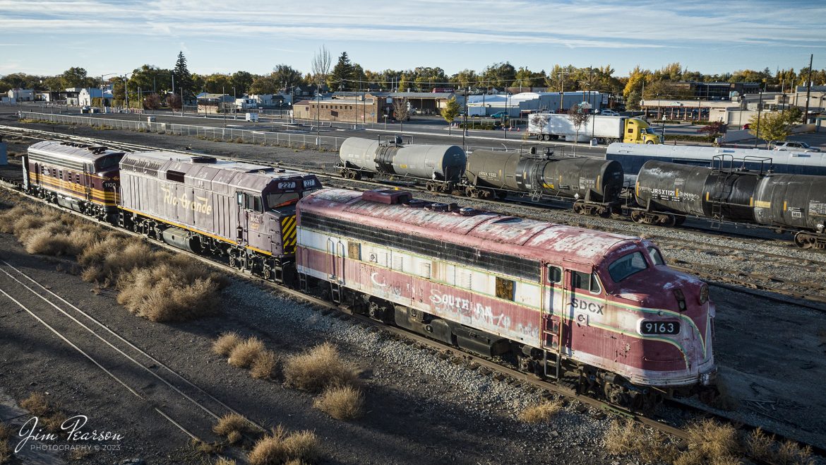 During my trip to Colorado to chase steam we stayed in Alamosa for the Cumbres and Toltec portion of the trip. On October 18th, 2023, I captured this lash-up of a Carolina Southern 9163 F7A unit, San Luis & Rio Grande (BUGX 227) and Rio Grande (BUGX 1100), sitting in the Colorado Pacific Rio Grande Railroad yard there. While I don’t normally capture scenes of locomotives that aren’t what I refer to as alive (have lights on, underpower or moving) I thought these old war horses warranted a photo.

I really don’t know a lot about them or their running condition, other than what I found on the web below.

Carolina Southern Railroad No. 9163 was built in 1950 and went to Canadian National Railway in 1952. Carolina Southern was an 80-mile short line based in Conway South Carolina that started service in 1995. The line shut down in 2011 and was sold to R. J. Corman in 2015. Locomotive No. 9163 was acquired by Iowa Pacific Holdings and was delivered to subsidiary San Luis & Rio Grande Railroad in Alamosa, Colorado. In 2022.

San Luis & Rio Grande (BUGX 227) F40PH-2, which was converted to a SLUG from what I find on the web, was built in May of 1976 and started its life as and engine in Amtrak’s fleet. According to the Diesel Shop its history is: ex LBWR/SLRG 227 (Lubbock & Western Railway); ex TNMR/SLRG 227 (Texas-New Mexico Railroad); ex SLRG 227; ex AMTK F40PH 227.

According to the San Luis & Rio Grande Railroad Roser site, (BUGX 1100) FP10 was built in December of 1946 as Built as GM&O F3A 805A, Rebuilt as FP10 MBTA 1100 and then To SLRG Aug-2006.

BUGX is Dieselmotive Company, Inc (Reporting mark: BUGX) is also known as the Bruggere and Monson Railroad is a company that owns, operates and maintains diesel locomotives. and according to the markings on the latter two engines, I assume they now own the 227 and 1100.

Tech Info: DJI Mavic 3 Classic Drone, RAW, 22mm, f/8, 1/2000, ISO 220.

#trainphotography #railroadphotography #trains #railways #jimpearsonphotography #trainphotographer #railroadphotographer #dronephoto #trainsfromadrone #ColoradoTrains #bugx