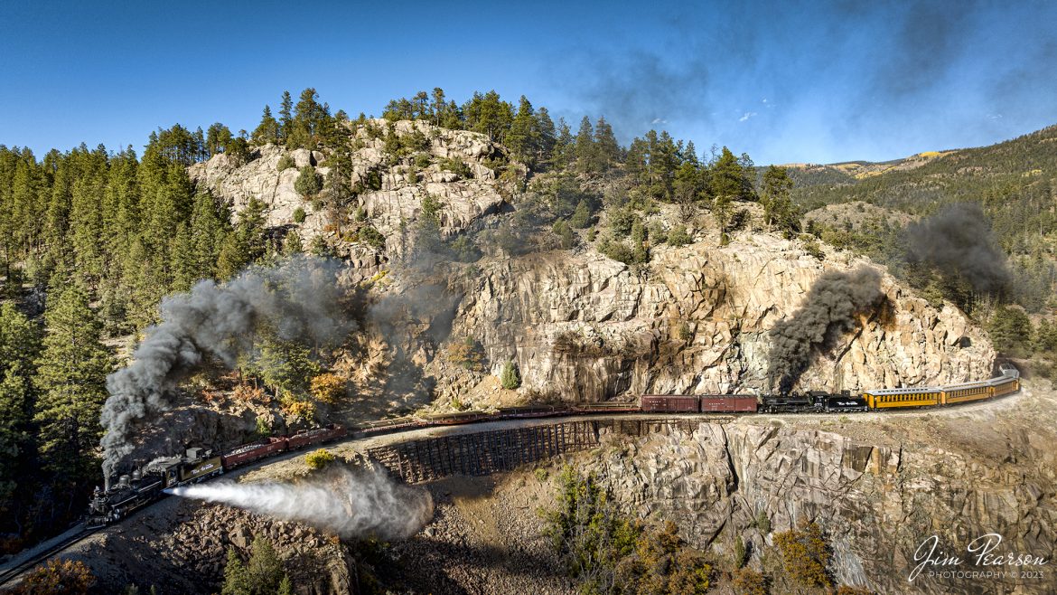 Denver and Rio Grande Western steam charter with locomotives 476 performing a blowdown and 473 as a mid-train helper pull a freight and passenger train through Horseshoe Curve during our two-day charter between Durango and Silverton, Colorado on October 17th, 2023.

A blowdown is a way to get minerals and other contaminants out of the system. Engines want to be on a bridge or trestle because the blow down itself can reach 30+ feet at an angle away from the firebox with live steam.

According to Wikipedia: The Durango and Silverton Narrow Gauge Railroad, often abbreviated as the D&SNG, is a 3 ft (914 mm) narrow-gauge heritage railroad that operates on 45.2 mi (72.7 km) of track between Durango and Silverton, in the U.S. state of Colorado. The railway is a federally designated National Historic Landmark and was also designated by the American Society of Civil Engineers as a National Historic Civil Engineering Landmark in 1968.

Tech Info: DJI Mavic 3 Classic Drone, RAW, 22mm, f/2.8, 1/1000, ISO 100.

railroad, railroads train, trains, best photo. sold photo, railway, railway, sold train photos, sold train pictures, steam trains, rail transport, railroad engines, pictures of trains, pictures of railways, best train photograph, best photo, photography of trains, steam, train photography, sold picture, best sold picture, Jim Pearson Photography, Durango and Silverton Railroad