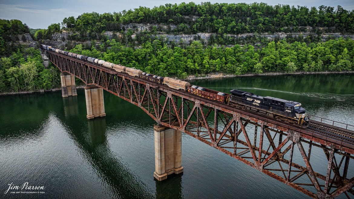 Norfolk Southern 4566 brings up the rear as DPU on 168 as it crosses over the Cumberland River Bridge at Burnside, Kentucky at sunset. as it heads north on the NS CNO&TP (Rathole) Second District on April 29th, 2024.

According to American-rails.com, It used to be called the Rathole Division when it was the Southern Railway and is often remembered as a road with relatively flat and tangent main lines due to the region in which it operated. However, the system did feature its share of steep, circuitous main lines such as Saluda Grade in western North Carolina and its famed “Rathole Division” through Kentucky and Tennessee that reached as far north as Cincinnati.

Technically, this stretch of the Southern main line was known as the 2nd District of subsidiary Cincinnati, New Orleans & Texas Pacific (CNO&TP), which was plagued for years by numerous tunnels resulting in its famous nickname by the crews which operated over it.

Over the years the Southern worked to daylight or bypass these obstacles as the route saw significant freight tonnage, a task finally completed during the 1960s. Today, the Rathole remains an important artery in Norfolk Southern’s vast network.

Tech Info: DJI Mavic 3 Classic Drone, RAW, 22mm, f/2.8, 1/120, ISO 180.

#railroad #railroads #train #trains #bestphoto #railroadengines #picturesoftrains #picturesofrailway #bestphotograph #photographyoftrains #trainphotography #JimPearsonPhotography #nscnotpsubdivision #norfolksouthern #trendingphoto