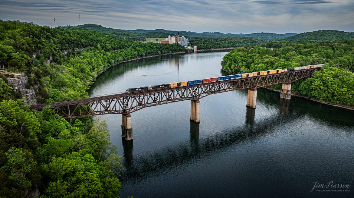 Norfolk Southern 168 crosses over the Cumberland River Bridge at Burnside, Kentucky as it heads north on the NS CNO&TP (Rathole) Second District on April 29th, 2024.

According to American-rails.com, It used to be called the Rathole Division when it was the Southern Railway and is often remembered as a road with relatively flat and tangent main lines due to the region in which it operated. However, the system did feature its share of steep, circuitous main lines such as Saluda Grade in western North Carolina and its famed “Rathole Division” through Kentucky and Tennessee that reached as far north as Cincinnati.

Technically, this stretch of the Southern main line was known as the 2nd District of subsidiary Cincinnati, New Orleans & Texas Pacific (CNO&TP), which was plagued for years by numerous tunnels resulting in its famous nickname by the crews which operated over it.

Over the years the Southern worked to daylight or bypass these obstacles as the route saw significant freight tonnage, a task finally completed during the 1960s. Today, the Rathole remains an important artery in Norfolk Southern’s vast network.

Tech Info: DJI Mavic 3 Classic Drone, RAW, 22mm, f/2.8, 1/160, ISO 120.

#railroad #railroads #train #trains #bestphoto #railroadengines #picturesoftrains #picturesofrailway #bestphotograph #photographyoftrains #trainphotography #JimPearsonPhotography #nscnotpsubdivision #norfolksouthern #trendingphoto