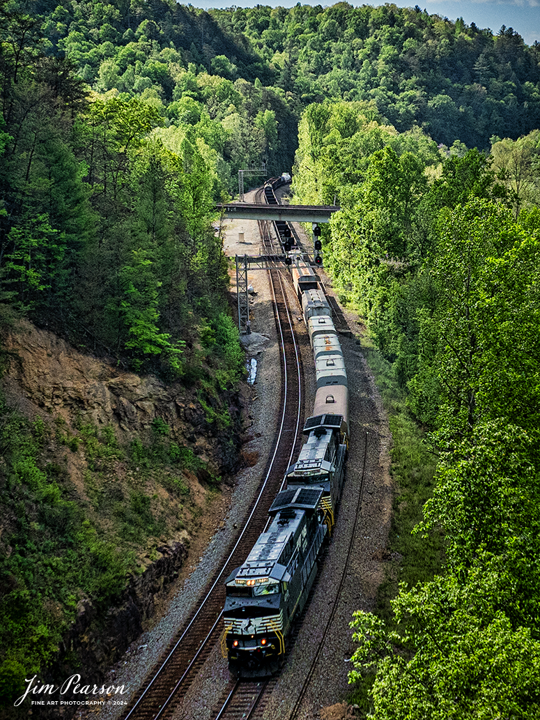 Norfolk Southern 49R snakes it's way along the Emory River as it heads northbound from CP Camp Austin at Oakdale, TN, on the NS CNO&TP (Rathole) Second District on April 29th, 2024.

According to Wikipedia: Oakdale was originally known as "Honeycutt" after an early settler, Allen Honeycutt. In the 1880s, the Cincinnati Southern Railway, which connected Chattanooga and Cincinnati, was built through the area, intersecting the vast system of the East Tennessee, Virginia and Georgia Railroad (later the Southern Railway) at Emory Gap near Harriman. Allen Honeycutt donated land to the railroad for construction of a switching point. In 1892, the name of the town was changed to "Oakdale" after a nearby mining operation.

The stretch of the Cincinnati Southern from Oakdale to Somerset, Kentucky, involves steep grades that were too difficult for normal late-19th and early-20th century steam-powered locomotives, so a railyard was set up at Oakdale where trains were modified to allow them to make the trek north. By the early 1900s, Oakdale had developed into an important railroad town, with a bank, five general stores, a drugstore, a hardware store, three schools, two churches, six secret societies, and a newspaper.

According to American-rails.com, It used to be called the Rathole Division when it was the Southern Railway and is often remembered as a road with relatively flat and tangent main lines due to the region in which it operated. However, the system did feature its share of steep, circuitous main lines such as Saluda Grade in western North Carolina and its famed “Rathole Division” through Kentucky and Tennessee that reached as far north as Cincinnati.

Technically, this stretch of the Southern main line was known as the 2nd District of subsidiary Cincinnati, New Orleans & Texas Pacific (CNO&TP), which was plagued for years by numerous tunnels resulting in its famous nickname by the crews which operated over it.

Over the years the Southern worked to daylight or bypass these obstacles as the route saw significant freight tonnage, a task finally completed during the 1960s. Today, the Rathole remains an important artery in Norfolk Southern’s vast network.

Tech Info: DJI Mavic 3 Classic Drone, RAW, 22mm, f/2.8, 1/3200, ISO 190.

#railroad #railroads #train #trains #bestphoto #railroadengines #picturesoftrains #picturesofrailway #bestphotograph #photographyoftrains #trainphotography #JimPearsonPhotography #nscnotpsubdivision #norfolksouthern #trendingphoto