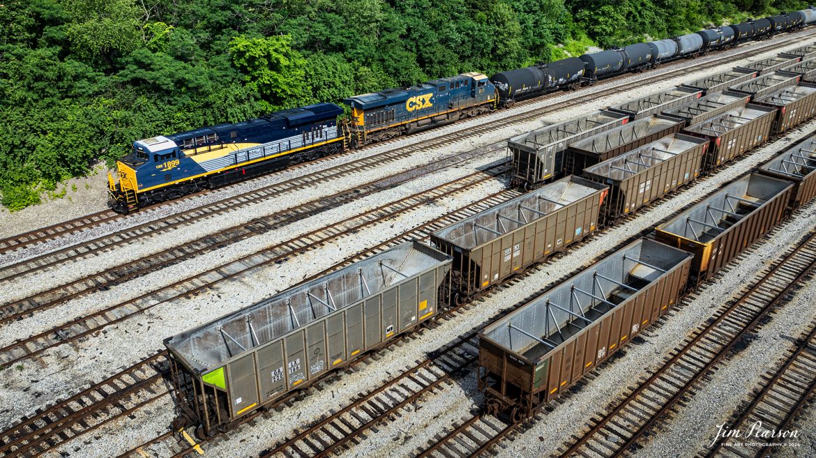 CSX M502 through the south end of Atkinson Yard at Madisonville, Ky with CSX Pere Marquette Heritage Unit, 1899, leading the way on the CSX Henderson Subdivision, on May 20th, 2024.

According to a CSX Press Release: May 1, 2024 - CSX has introduced the latest addition in its heritage locomotive series, paying homage to the rich history of the Pere Marquette Railroad. This new unit showcases the Pere Marquette's legacy, dating back to its inception on November 1, 1899.
 
The Pere Marquette Railroad, operating in the Great Lakes region of the United States and parts of southern Ontario, Canada, derived its name from Jacques Marquette, a notable French Jesuit missionary credited with founding Michigan's first European settlement in Sault Ste Marie. After years of operation, the company merged with the Chesapeake and Ohio Railway (C&O) on June 6, 1947, eventually becoming part of the renowned CSX network.
 
The design of the Pere Marquette heritage locomotive was meticulously crafted by employees at the CSX Waycross Locomotive Shop. According to CSX Carman Painter Eric Lee, “We had to measure each stripe precisely and position the words just right to ensure it captured the look of the original design. It took us about four days just to lay out the stripes before we could begin painting.”
 
A fascinating tidbit related to the history of Pere Marquette is its cameo in the 2004 film "The Polar Express." The steam locomotive Pere Marquette 1225 served as the inspiration for the train depicted in the movie, with audio recordings of the actual locomotive in operation featured in the film. Interestingly, the locomotive had been donated to Michigan State University and was exhibited near the university's football stadium. The author of "The Polar Express" book drew inspiration from seeing this locomotive on display during childhood, solidifying its place in popular culture.
 
CSX's dedication to honoring the history and significance of the Pere Marquette Railroad through this new locomotive underscores the company's commitment to preserving and celebrating the heritage of American railroads. Keep an eye out as this remarkable piece of history moves across the CSX network, bridging the past with the present.

Tech Info: DJI Mavic 3 Classic Drone, RAW, 22mm, f/2.8, 1/1000, ISO 100.

#railroad #railroads #train, #trains #railway #railway #steamtrains #railtransport #railroadengines #picturesoftrains #picturesofrailways #besttrainphotograph #bestphoto #photographyoftrains #steamtrainphotography #CSXPereMarquetteheritageunit #bestsoldpicture #JimPearsonPhotography #csxheritagelocomotive