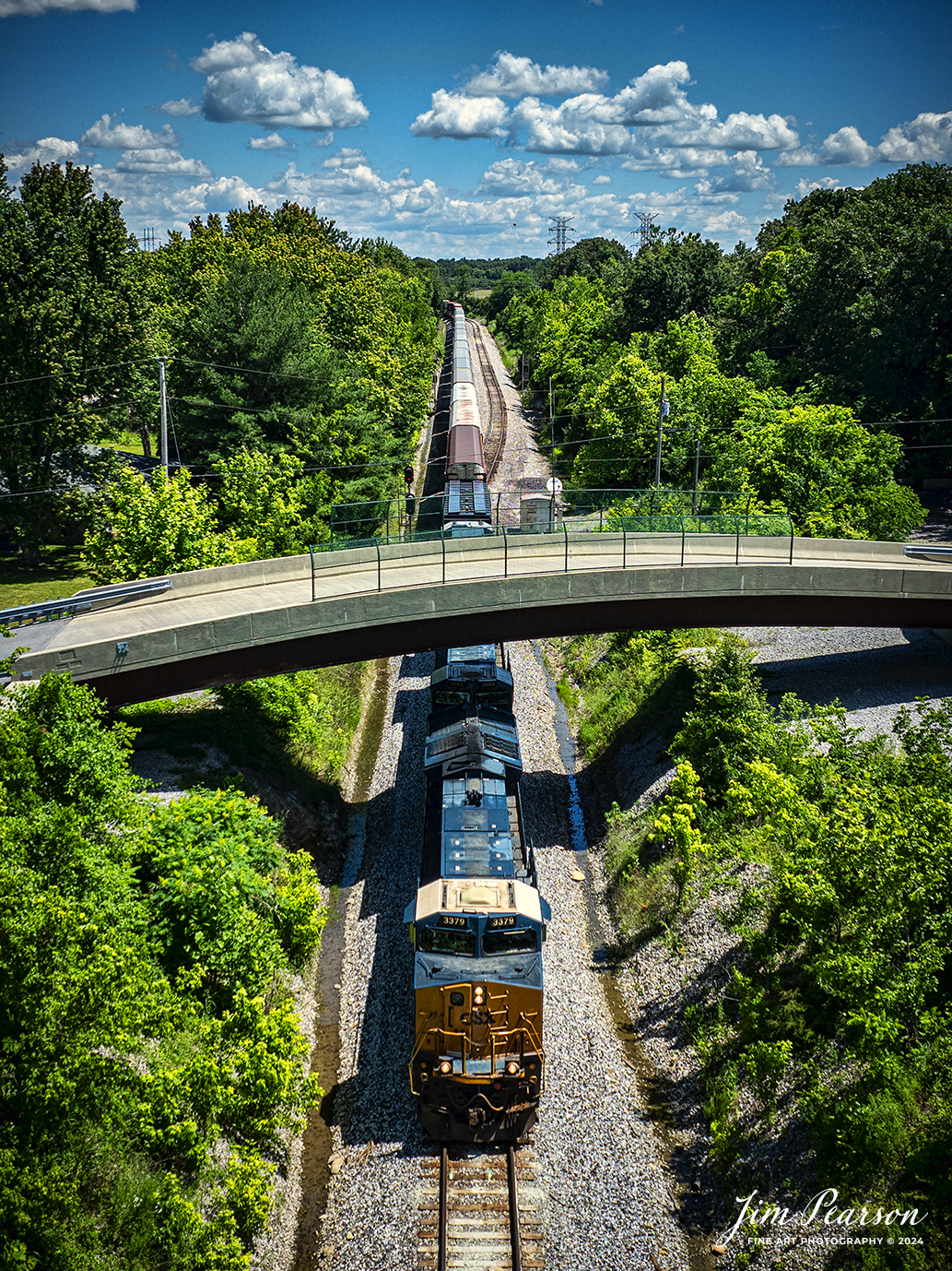 CSXT 3379 leads CSX intermodal I025 south under the Sub Station Road overpass at south end of the siding at Kelly, Kentucky, on the CSX Henderson on May 30th, 2024. This intermodal normally runs with a string of autoracks which contain Tesla automobiles that are bound for Florida.

Tech Info: DJI Mavic 3 Classic Drone, RAW, 22mm, f/2.8, 1/2000, ISO 120.

#railroad #railroads #train #trains #bestphoto #railroadengines #picturesoftrains #picturesofrailway #bestphotograph #photographyoftrains #trainphotography #JimPearsonPhotography #trendingphoto #csxt #trainsfromadrone