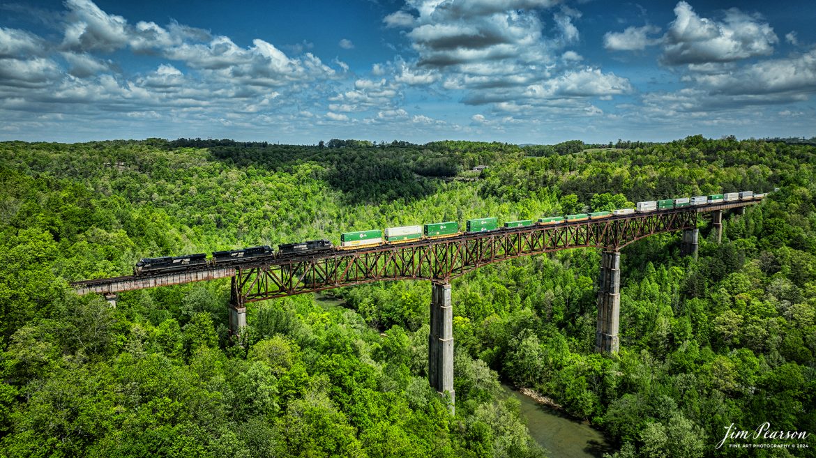 A trio of Norfolk Southern engines lead NS 29F as they make their way across the New River Bridge southbound on the NS CNO&TP (Rathole) Second District at New River, Tennessee. On April 29th, 2024.  

According to the Historic Bridges website: This bridge is a very large high level deck cantilever truss bridge. It was constructed in 1963 and as such is a late example of its type, but still noteworthy as an uncommon structure type and for its size. Typical of 1960s truss bridges, the bridge still has riveted built-up beams, but v-lacing and lattice are absent in the built-up beams, and truss connections are bolted instead of riveted. It is 1,622.0 Feet (494.4 Meters) long, with 3 Main Span(s) and 6 Approach Span(s) is over 300 feet above the river.

Tech Info: DJI Mavic 3 Classic Drone, RAW, 22mm, f/2.8, 1/2000, ISO 100.

#railroad #railroads #train #trains #bestphoto #railroadengines #picturesoftrains #picturesofrailway #bestphotograph #photographyoftrains #trainphotography #JimPearsonPhotography #nscnotpsubdivision #norfolksouthern #trendingphoto #nsnewriverbridge