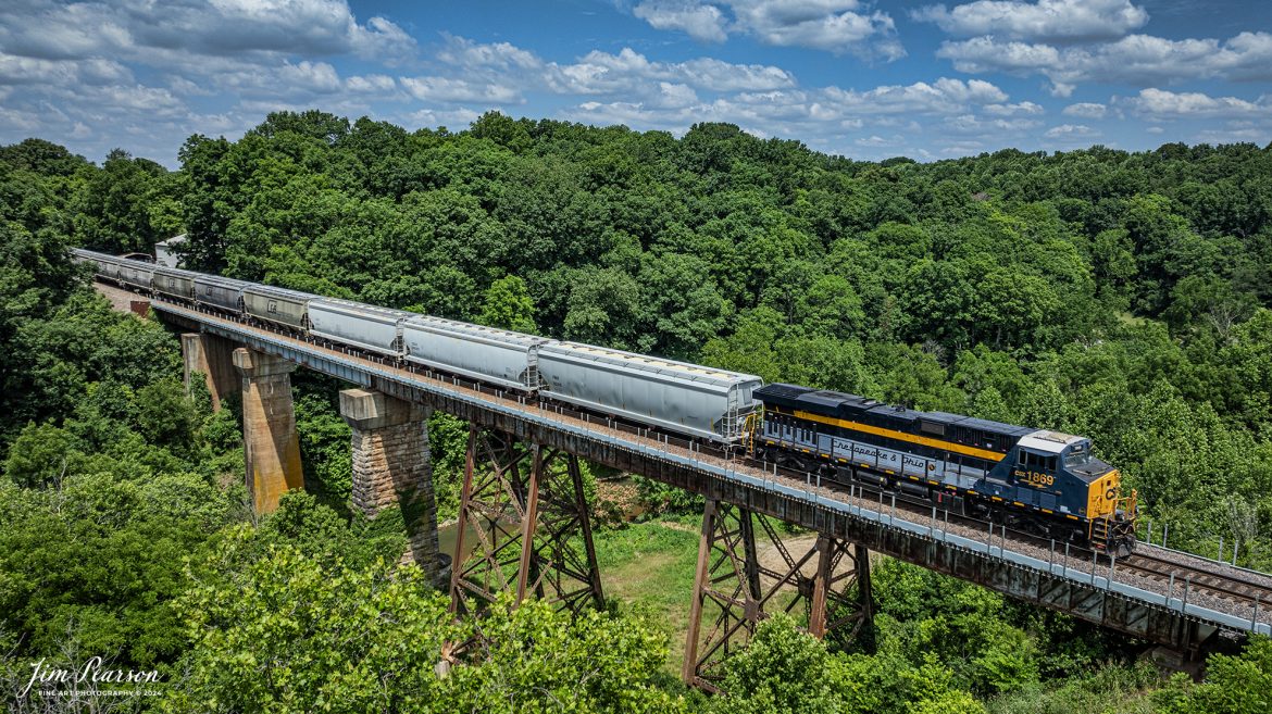 CSX Chesapeake and Ohio Heritage unit 1868 leads M503 as it heads south over the Sulfur Fork bridge just north of Springfield, Tennessee on the Henderson Subdivision on the first day of summer, June 20th, 2024.

From a CSX Press Release: A locomotive commemorating the proud history of the Chesapeake and Ohio Railway has entered service as the fifth in the CSX heritage series celebrating the lines that came together to form the modern railroad.

Numbered CSX 1869 in honor of the year the C&O was formed in Virginia from several smaller railroads, the newest heritage locomotive sports a custom paint design that includes today’s CSX colors on the front of the engine and transitions to a paint scheme inspired by 1960s era C&O locomotives on the rear two-thirds.

The C&O Railway was a major line among North American freight and passenger railroads for nearly a century before becoming part of the Chessie System in 1972 and eventually merging into the modern CSX. In 1970, the C&O included more than 5,000 route miles of track stretching from Newport News, Virginia, to Chicago and the Great Lakes.

Tech Info: DJI Mavic 3 Classic Drone, RAW, 22mm, f/2.8, 1/2000, ISO 100.

#railroad #railroads #train #trains #bestphoto #railroadengines #picturesoftrains #picturesofrailway #bestphotograph #photographyoftrains #trainphotography #JimPearsonPhotography #trendingphoto #csxt #trainsfromadrone #csxheritage