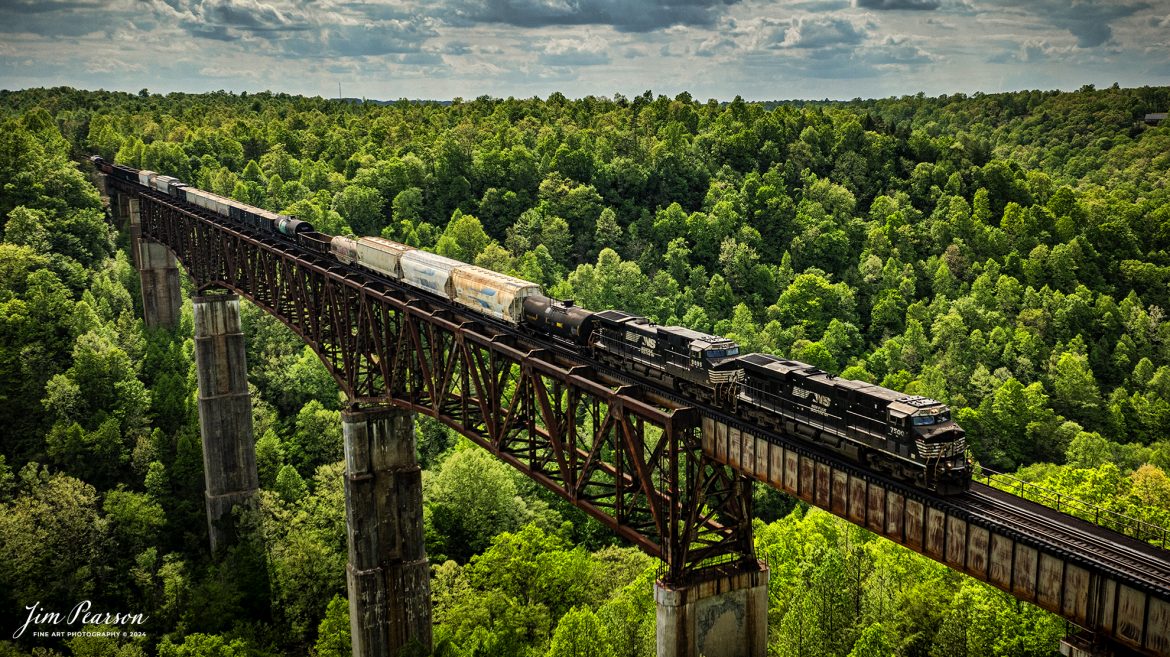 A set of Norfolk Southern engines lead NS 168 as they make their way across the New River Bridge northbound on the NS CNO&TP (Rathole) Subdivision at New River, Tennessee. On April 29th, 2024.  

According to the Historic Bridges website: This bridge is a very large high level deck cantilever truss bridge. It was constructed in 1963 and as such is a late example of its type, but still noteworthy as an uncommon structure type and for its size. Typical of 1960s truss bridges, the bridge still has riveted built-up beams, but v-lacing and lattice are absent in the built-up beams, and truss connections are bolted instead of riveted. It is 1,622.0 Feet (494.4 Meters) long, with 3 Main Span(s) and 6 Approach Span(s) is over 300 feet above the river.

Tech Info: DJI Mavic 3 Classic Drone, RAW, 22mm, f/2.8, 1/2500, ISO 160.

#railroad #railroads #train #trains #bestphoto #railroadengines #picturesoftrains #picturesofrailway #bestphotograph #photographyoftrains #trainphotography #JimPearsonPhotography #nscnotpsubdivision #norfolksouthern #trendingphoto #nsnewriverbridge