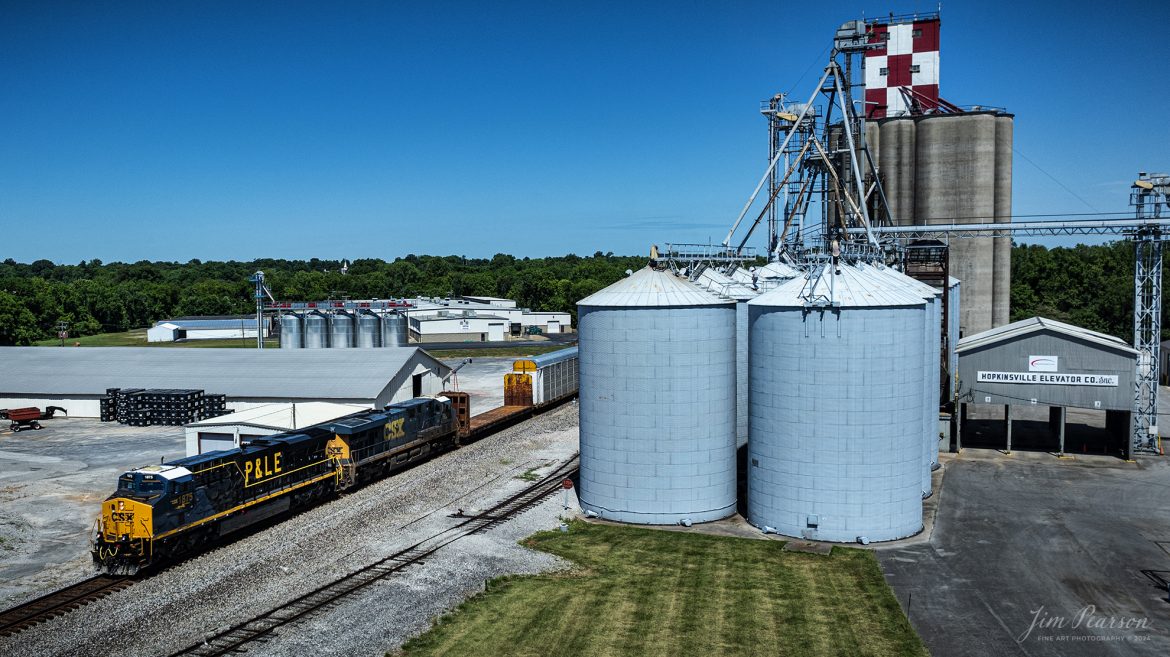 CSX M513 heads southbound with CSX Pittsburgh & Lake Erie Railroad Heritage Unit (P&LE), 1875, leading the way as they pass the Hopkinsville Elevator Company at Hopkinsville, Ky on the CSX Henderson Subdivision, on June 24th, 2024. 

According to a CSX Press Release: June 6, 2024 - CSX has released a new heritage locomotive, the P&LE 1875, paying tribute to the storied Pittsburgh & Lake Erie Railroad (P&LE). The 15th in CSX’s heritage locomotive series, this new addition to the company’s fleet not only celebrates the rich history of P&LE but also marks a significant milestone in CSX's ongoing commitment to honoring the legacies of America's historic railroads.

The Pittsburgh & Lake Erie Railroad was established in 1875 with a primary mission of transporting essential industrial materials such as coal, coke, iron ore, limestone, and steel among the bustling industrial hubs of the region. 

“It’s mainline connected Pittsburgh, Pennsylvania with Youngstown, Ohio and Connellsville, Pennsylvania. It did not actually reach Lake Erie until 1976,” explained Tim Music, a carman painter at the CSX Waycross Locomotive Shop where the unit was produced.

Despite its relatively modest route mileage, the P&LE Railroad earned the nickname "Little Giant" due to the enormous volume of heavy tonnage it moved. This impressive capability drew significant attention and by 1887, the P&LE became a subsidiary of the dominant New York Central Railroad. Under this new ownership, the P&LE enjoyed substantial improvements to its tracks and added capacity for passenger services, further enhancing its regional significance.

Over time, P&LE expanded by leasing branches from smaller railroads. These extensions included lines southeast along the Monongahela River through Homestead and McKeesport, and along the Youghiogheny River to Connellsville, where it connected with the Western Maryland Railway.

Tech Info: DJI Mavic 3 Classic Drone, RAW, 22mm, f/2.8, 1/2000, ISO 100.

#railroad #railroads #train, #trains #railway #railway #steamtrains #railtransport #railroadengines #picturesoftrains #picturesofrailways #besttrainphotograph #bestphoto #photographyoftrains #steamtrainphotography #CSXPLEheritageunit #bestsoldpicture #JimPearsonPhotography #csxheritagelocomotive