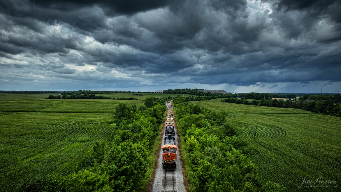 BNSF 6387 and 3947 lead CSX S577 as the crew backs a loaded military train onto the Ft. Campbell lead at Hopkinsville, Ky, from the CSX Henderson Subdivision on July 9th, 2024, under threatening skies during a Tornado Warning spawned by the remnants of Hurricane Alberto. Fellow railfan Brian Caswell and I sat for a couple hours hoping that Ft. Campbell would show up to carry the equipment onto the base, but unfortunately it didn’t happen. Despite the warnings here very little rain fell and most of the tornados spawned in our area were more to the northeast up in Indiana.

Tech Info: DJI Mavic 3 Classic Drone, RAW, 22mm, f/2.8, 1/1000, ISO 170.

#railroad #railroads #train #trains #bestphoto #railroadengines #picturesoftrains #picturesofrailway #bestphotograph #photographyoftrains #trainphotography #JimPearsonPhotography #trendingphoto #militarytrains #stormyweather