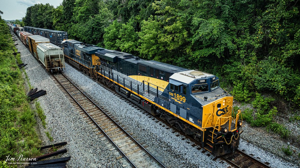 CSX I025 heads northbound with CSX Pere Marquette Heritage Unit 1899, leading the way along the CSX Henderson Subdivision, as they pass the tail end of M647 at Kelly, Kentucky, on July 18th, 2024. 

According to a CSX Press Release: May 1, 2024 - CSX has introduced the latest addition in its heritage locomotive series, paying homage to the rich history of the Pere Marquette Railroad. This new unit showcases the Pere Marquette's legacy, dating back to its inception on November 1, 1899.
 
The Pere Marquette Railroad, operating in the Great Lakes region of the United States and parts of southern Ontario, Canada, derived its name from Jacques Marquette, a notable French Jesuit missionary credited with founding Michigan's first European settlement in Sault Ste Marie. After years of operation, the company merged with the Chesapeake and Ohio Railway (C&O) on June 6, 1947, eventually becoming part of the renowned CSX network.
 
The design of the Pere Marquette heritage locomotive was meticulously crafted by employees at the CSX Waycross Locomotive Shop. According to CSX Carman Painter Eric Lee, “We had to measure each stripe precisely and position the words just right to ensure it captured the look of the original design. It took us about four days just to lay out the stripes before we could begin painting.”
 
A fascinating tidbit related to the history of Pere Marquette is its cameo in the 2004 film "The Polar Express." The steam locomotive Pere Marquette 1225 served as the inspiration for the train depicted in the movie, with audio recordings of the actual locomotive in operation featured in the film. Interestingly, the locomotive had been donated to Michigan State University and was exhibited near the university's football stadium. The author of "The Polar Express" book drew inspiration from seeing this locomotive on display during childhood, solidifying its place in popular culture.
 
CSX's dedication to honoring the history and significance of the Pere Marquette Railroad through this new locomotive underscores the company's commitment to preserving and celebrating the heritage of American railroads. Keep an eye out as this remarkable piece of history moves across the CSX network, bridging the past with the present.

Tech Info: DJI Mavic 3 Classic Drone, RAW, 22mm, f/2.8, 1/1600, ISO 230.

#railroad #railroads #train, #trains #railway #railway #steamtrains #railtransport #railroadengines #picturesoftrains #picturesofrailways #besttrainphotograph #bestphoto #photographyoftrains #steamtrainphotography #CSXPereMarquetteheritageunit #bestsoldpicture #JimPearsonPhotography #csxheritagelocomotive