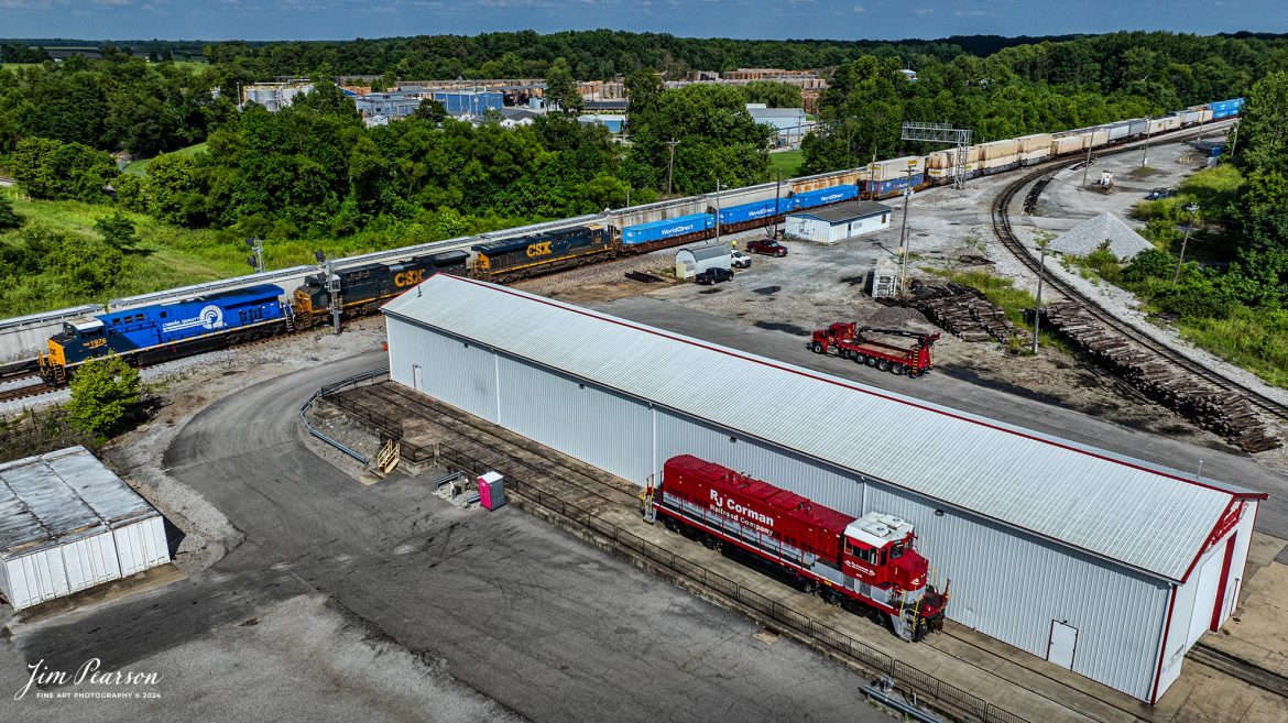 The CSX Conrail Heritage Locomotive leads CSX I026 northbound past the RJ Corman engine house on July 18th, 2024, on the CSX Henderson Subdivision as they make their daily run to Chicago, Illinois. Next to the engine house is RJC Genset 2698.

According to a CSX Press Release: July 22, 2023 – CSX has unveiled the fourth locomotive in its series of custom paint designs that honor its heritage railroads. The latest in the series commemorates the Consolidated Rail Corporation, or Conrail, and bears the number 1976, the year the railroad was founded.

CSX and Norfolk Southern acquired and divided most of the Conrail network in 1997. Today, the company continues to exist as a terminal and switching railroad for CSX and NS customers in North Jersey-New York City metro area.

The Conrail paint scheme of a double-lined C inside a large, bold Q was a fixture for many years across the Northeast where the majority of the railroad’s operations were centered. The heritage locomotive design conceived and executed at CSX’s locomotive shop in Waycross, Georgia, recreates the iconic “Conrail Quality” logo and features Conrail blue on the rear two-thirds of the engine, then transitions to the current CSX colors and design on the cab portion of the unit.

CSX 1976 and other locomotives in the heritage series will be placed into revenue service and travel CSX’s 20,000 rail network, reinforcing employee pride in the history of the railroad that continues to move the nation’s economy with safe, reliable and sustainable rail-based transportation services.

Tech Info: DJI Mavic 3 Classic Drone, RAW, 22mm, f/2.8, 1/3200, ISO 100.

#railroad #railroads #train #trains #bestphoto #railroadengines #picturesoftrains #picturesofrailway #bestphotograph #photographyoftrains #trainphotography #JimPearsonPhotography #trendingphoto