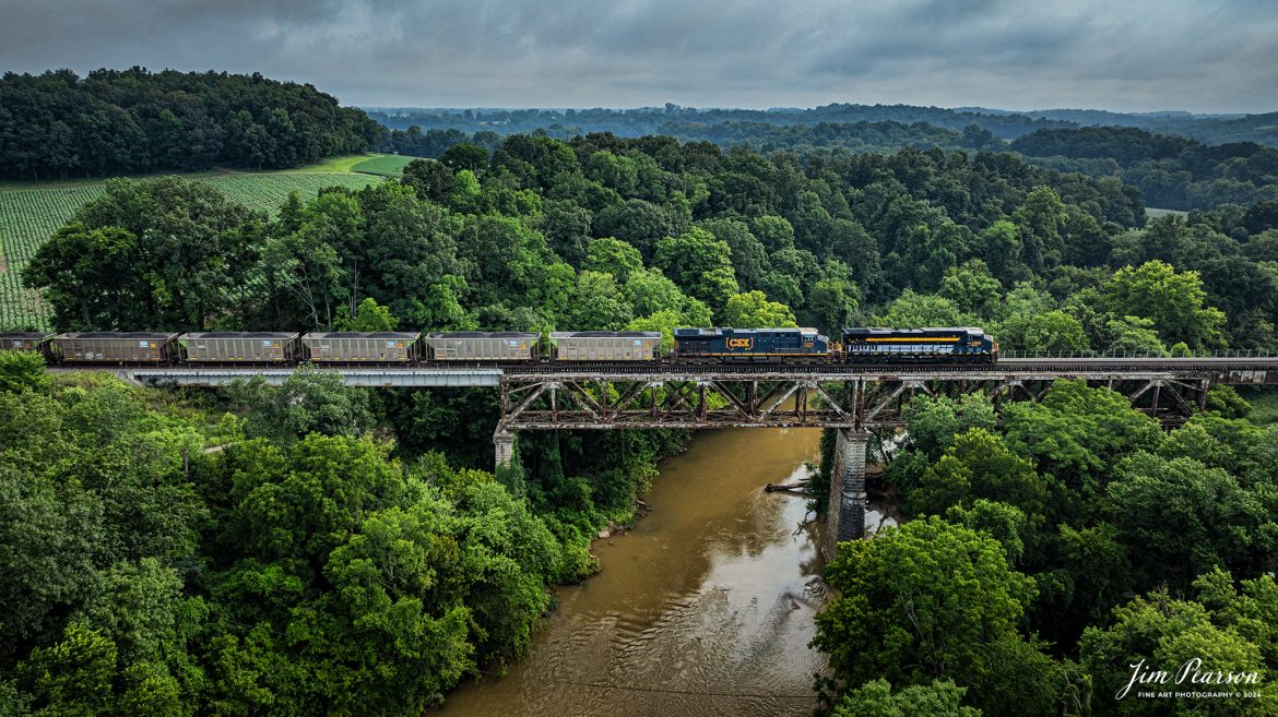 CSX Chesapeake & Ohio Heritage unit 1869 as it leads loaded coal train C040 across the Red River Bridge at Adams, Tennessee southbound on the Henderson Subdivision on July 25th, 2024.

According to the CSX Website: A locomotive commemorating the proud history of the Chesapeake and Ohio Railway has entered service as the fifth in the CSX heritage series celebrating the lines that came together to form the modern railroad.

Numbered CSX 1869 in honor of the year the C&O was formed in Virginia from several smaller railroads, the newest heritage locomotive sports a custom paint design that includes today’s CSX colors on the front of the engine and transitions to a paint scheme inspired by 1960s era C&O locomotives on the rear two-thirds.

The C&O Railway was a major line among North American freight and passenger railroads for nearly a century before becoming part of the Chessie System in 1972 and eventually merging into the modern CSX. In 1970, the C&O included more than 5,000 route miles of track stretching from Newport News, Virginia, to Chicago and the Great Lakes.

Designed and painted at CSXs locomotive shop in Waycross, Georgia, the C&O unit will join four other commemorative units in revenue service on CSXs 20,000-mile rail network.

The heritage series is reinforcing employee pride in the history of the railroad that continues to move the nation’s economy with safe, reliable, and sustainable rail-based transportation services.

Tech Info: DJI Mavic 3 Classic Drone, RAW, 22mm, f/2.8, 1/1250, ISO 240.

#railroad #railroads #train #trains #bestphoto #railroadengines #picturesoftrains #picturesofrailway #bestphotograph #photographyoftrains #trainphotography #JimPearsonPhotography #trendingphoto #csxt #trainsfromadrone #csxheritage