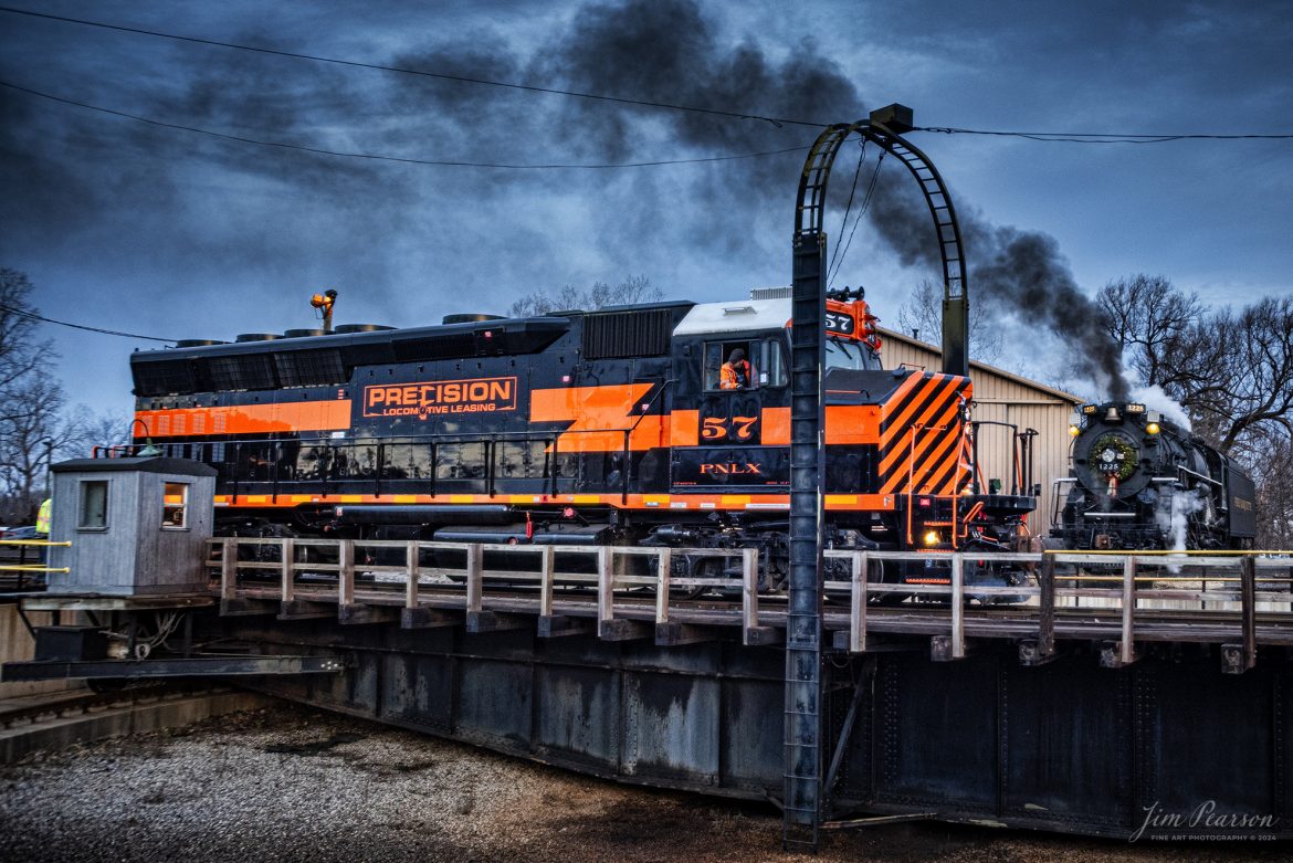 Precision Locomotive Leasing #57 backs off the Steam Railroad Institute turntable at Owosso, Michigan, as it prepares for a day of pulling the North Pole Express to Ashley, Michigan on December 16th, 2023, while in the background the crew on Pere Marquette 1225 works at dumping the ash from the locomotive as both trains prepare for a day of pulling passengers .

According to their website, Pere Marquette 1225, the largest and most impressive piece in the Steam Railroading Institute’s collection, is one of the largest operating steam locomotives in Michigan. The 1225 was built in October of 1941 by the Lima Locomotive Works in Lima, Ohio for the Pere Marquette Railway. It’s part of the National Register of Historic Structures and is renowned for its role in the 2004 Warner Brothers Christmas Classic, THE POLAR EXPRESS™. 1225’s blueprints were used as the prototype for the locomotive image as well as its sounds to bring the train in the animated film to life!

Precision Locomotive Leasing is the locomotive leasing and sales subsidiary of Precision Locomotive Services, a locomotive repair and service company, based in Staunton, Virginia. The company mainly serves the Eastern United States.

Tech Info: Nikon D810, RAW, Sigma 24-70 @ 24mm, f/2.8, 1/250, ISO 800.

#railroad #railroads #train, #trains #railway #railway #steamtrains #railtransport #railroadengines #picturesoftrains #picturesofrailways #besttrainphotograph #bestphoto #photographyoftrains #steamtrainphotography # PereMarquette1225 #bestsoldpicture #JimPearsonPhotography #northpoleexpress #owossomichigan #SteamRailroadingInstitute