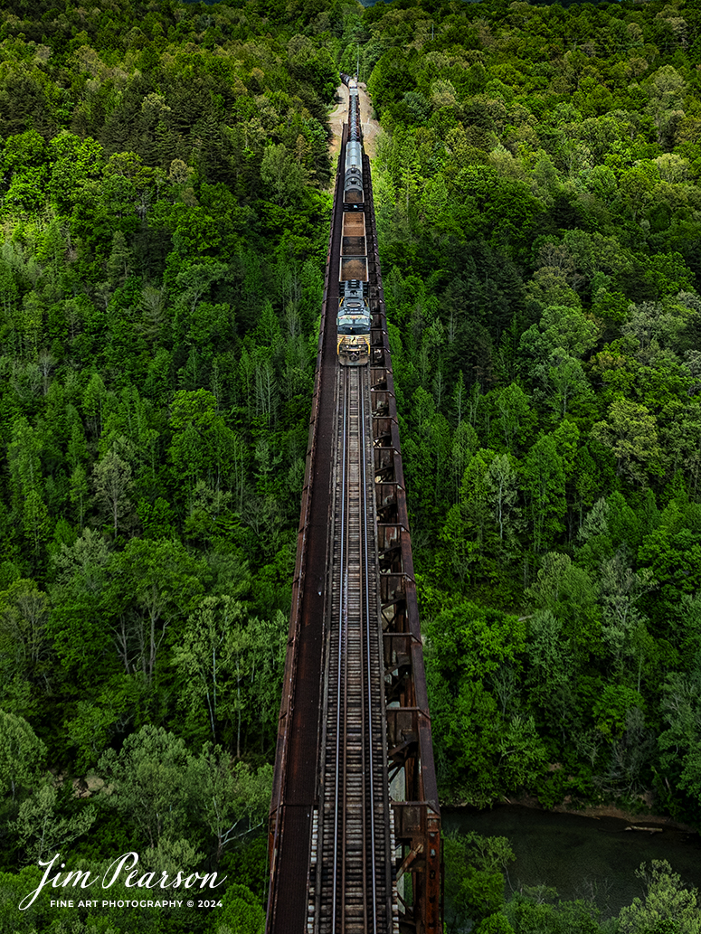 A single Norfolk Southern engine lead brings up the rear as DPU on NS 168 as they make their way across the New River Bridge northbound on the NS CNO&TP (Rathole) Subdivision at New River, Tennessee. On April 29th, 2024.  

According to the Historic Bridges website: This bridge is a very large high level deck cantilever truss bridge. It was constructed in 1963 and as such is a late example of its type, but still noteworthy as an uncommon structure type and for its size. Typical of 1960s truss bridges, the bridge still has riveted built-up beams, but v-lacing and lattice are absent in the built-up beams, and truss connections are bolted instead of riveted. It is 1,622.0 Feet (494.4 Meters) long, with 3 Main Span(s) and 6 Approach Span(s) is over 300 feet above the river.

Tech Info: DJI Mavic 3 Classic Drone, RAW, 22mm, f/2.8, 1/1600, ISO 110.

#railroad #railroads #train #trains #bestphoto #railroadengines #picturesoftrains #picturesofrailway #bestphotograph #photographyoftrains #trainphotography #JimPearsonPhotography #nscnotpsubdivision #norfolksouthern #trendingphoto #nsnewriverbridge