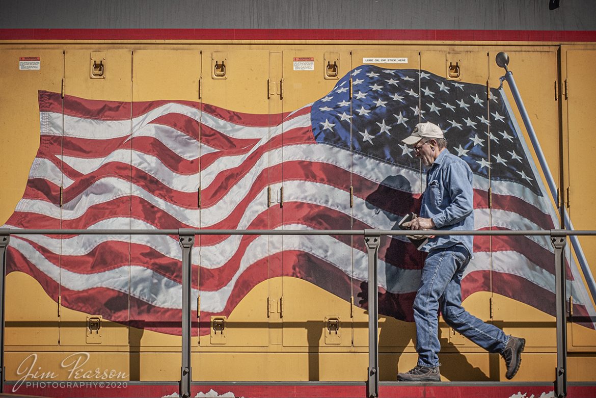 May 1, 2005 - Blast From The Past - The conductor on a Union Pacific freight walks past the American Flag on his engine in the yard at Salem, Illinois.

According to the Union Pacific Website: When we added the flag to our locomotives more than a decade ago – at the suggestion of an employee after 9/11 – we followed the tradition of having the Union (the blue field of stars) lead the way, such that on the right-hand side of the vehicle ("passenger side"), the flag would appear reversed. 

Further, the flag was painted to convey the motion of forward movement as if it were billowing with the speed of the locomotive. Having the Union forward on both sides is the overwhelming choice anytime the flag is portrayed on a transport vehicle, from NASA space shuttles to Air Force One.

Tech Info: Nikon D100, Nikon 70-300mm @ 80mm, f/14, 1/400, ISO 400.

#railroad #railroads #train #trains #bestphoto #railroadengines #picturesoftrains #picturesofrailway #bestphotograph #photographyoftrains #trainphotography #JimPearsonPhotography #trendingphoto