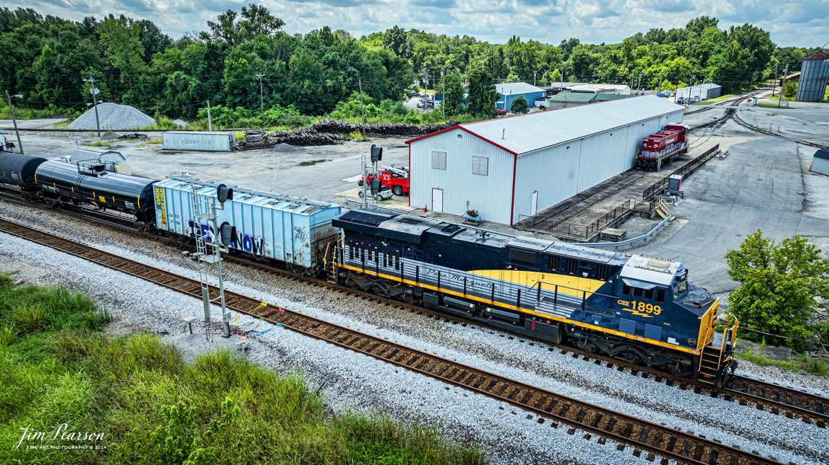 CSX empty ethanol train B722 with CSX Pere Marquette Heritage Unit 1899 leading the way on the CSX Henderson Subdivision heads northbound at Guthrie, Ky, on July 31st, 2024, past the RJ Corman facility. Next to the engine house is RJC Genset 2698.

According to a CSX Press Release: May 1, 2024 – CSX has introduced the latest addition in its heritage locomotive series, paying homage to the rich history of the Pere Marquette Railroad. This new unit showcases the Pere Marquette’s legacy, dating back to its inception on November 1, 1899.

The Pere Marquette Railroad, operating in the Great Lakes region of the United States and parts of southern Ontario, Canada, derived its name from Jacques Marquette, a notable French Jesuit missionary credited with founding Michigan’s first European settlement in Sault Ste Marie. After years of operation, the company merged with the Chesapeake and Ohio Railway (C&O) on June 6, 1947, eventually becoming part of the renowned CSX network.

The design of the Pere Marquette heritage locomotive was meticulously crafted by employees at the CSX Waycross Locomotive Shop. According to CSX Carman Painter Eric Lee, “We had to measure each stripe precisely and position the words just right to ensure it captured the look of the original design. It took us about four days just to lay out the stripes before we could begin painting.”

A fascinating tidbit related to the history of Pere Marquette is its cameo in the 2004 film “The Polar Express.” The steam locomotive Pere Marquette 1225 served as the inspiration for the train depicted in the movie, with audio recordings of the actual locomotive in operation featured in the film. Interestingly, the locomotive had been donated to Michigan State University and was exhibited near the university’s football stadium. The author of “The Polar Express” book drew inspiration from seeing this locomotive on display during childhood, solidifying its place in popular culture.

CSX’s dedication to honoring the history and significance of the Pere Marquette Railroad through this new locomotive underscores the company’s commitment to preserving and celebrating the heritage of American railroads. Keep an eye out as this remarkable piece of history moves across the CSX network, bridging the past with the present.

Tech Info: DJI Mavic 3 Classic Drone, RAW, 22mm, f/2.8, 1/2000, ISO 150.

#railroad #railroads #train #trains #bestphoto #railroadengines #picturesoftrains #picturesofrailway #bestphotograph #photographyoftrains #trainphotography #JimPearsonPhotography #trendingphoto #csxt #trainsfromadrone #csxheritage