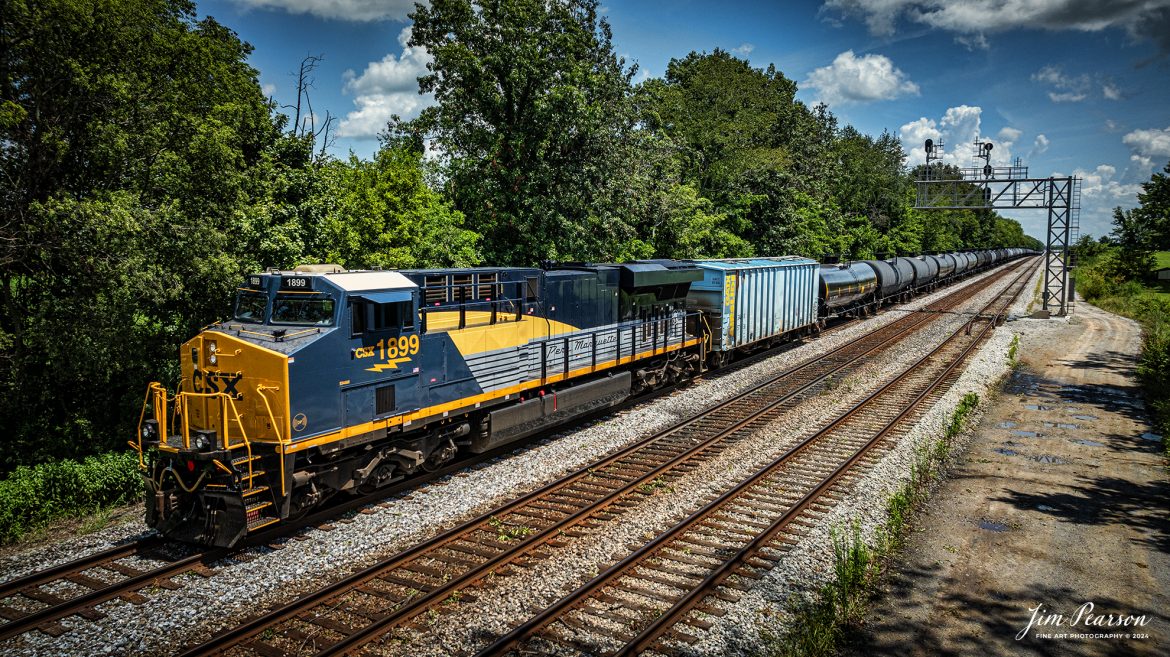 CSX empty ethanol train B722 with CSX Pere Marquette Heritage Unit 1899 leading the way on the CSX Henderson Subdivision meets northbound M513 at Casky in Hopkinsville, Ky, on July 31st, 2024.

According to a CSX Press Release: May 1, 2024 – CSX has introduced the latest addition in its heritage locomotive series, paying homage to the rich history of the Pere Marquette Railroad. This new unit showcases the Pere Marquette’s legacy, dating back to its inception on November 1, 1899.

The Pere Marquette Railroad, operating in the Great Lakes region of the United States and parts of southern Ontario, Canada, derived its name from Jacques Marquette, a notable French Jesuit missionary credited with founding Michigan’s first European settlement in Sault Ste Marie. After years of operation, the company merged with the Chesapeake and Ohio Railway (C&O) on June 6, 1947, eventually becoming part of the renowned CSX network.

The design of the Pere Marquette heritage locomotive was meticulously crafted by employees at the CSX Waycross Locomotive Shop. According to CSX Carman Painter Eric Lee, “We had to measure each stripe precisely and position the words just right to ensure it captured the look of the original design. It took us about four days just to lay out the stripes before we could begin painting.”

A fascinating tidbit related to the history of Pere Marquette is its cameo in the 2004 film “The Polar Express.” The steam locomotive Pere Marquette 1225 served as the inspiration for the train depicted in the movie, with audio recordings of the actual locomotive in operation featured in the film. Interestingly, the locomotive had been donated to Michigan State University and was exhibited near the university’s football stadium. The author of “The Polar Express” book drew inspiration from seeing this locomotive on display during childhood, solidifying its place in popular culture.

CSX’s dedication to honoring the history and significance of the Pere Marquette Railroad through this new locomotive underscores the company’s commitment to preserving and celebrating the heritage of American railroads. Keep an eye out as this remarkable piece of history moves across the CSX network, bridging the past with the present.

Tech Info: DJI Mavic 3 Classic Drone, RAW, 22mm, f/2.8, 1/1600, ISO 100.

#railroad #railroads #train #trains #bestphoto #railroadengines #picturesoftrains #picturesofrailway #bestphotograph #photographyoftrains #trainphotography #JimPearsonPhotography #trendingphoto #csxt #trainsfromadrone #csxheritage