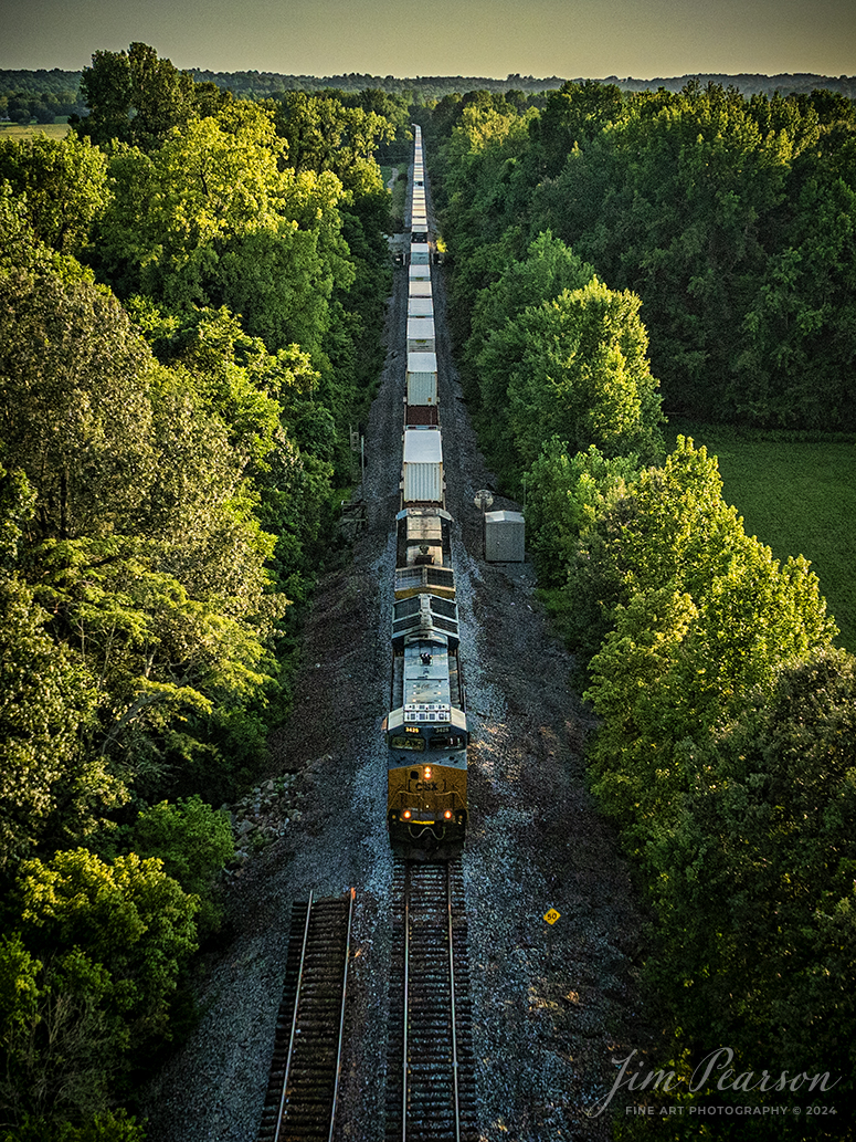 CSXT 3425 leads CSX I026 north as it passes what used to be the south end of the siding at Hanson, Kentucky on the Henderson Subdivision, during golden hour light, on July 31st, 2024. The switch for the siding here was removed a few weeks ago and now the short siding at Hanson serves as a house track.

Tech Info: DJI Mavic 3 Classic Drone, RAW, 22mm, f/2.8, 1/2000, ISO 370.

#railroad #railroads #train #trains #bestphoto #railroadengines #picturesoftrains #picturesofrailway #bestphotograph #photographyoftrains #trainphotography #JimPearsonPhotography #trendingphoto #csxt #trainsfromadrone