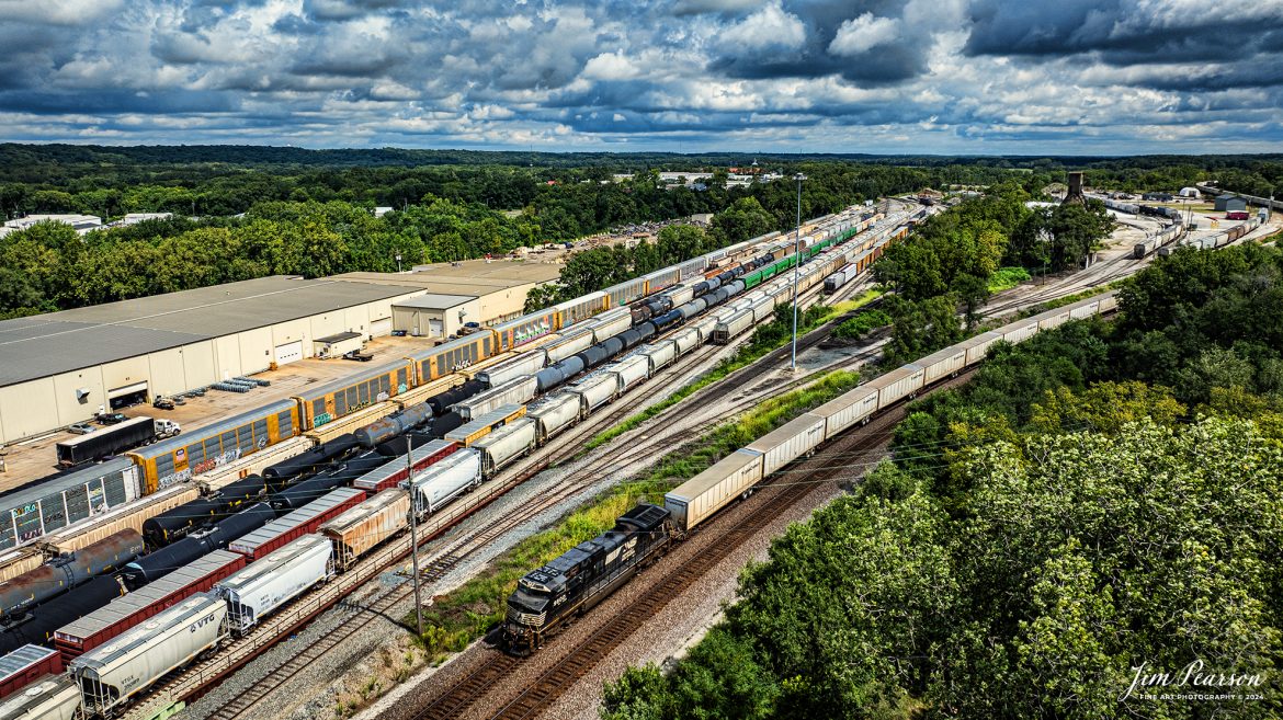 Norfolk Southern 9800 leads westbound Triple Crown RoadRailer train NS 255 as it heads out of the NS Lafayette East Yard at Lafayette, Indiana,while passing the CSX yard, on the NS Lafayette District on August 17th, 2024.

The RoadRailer trains will become a thing of the past as of the weekend of 24-25th of August 2024, as the service will be discontinued and transitioned fully to standard double-stack trains.

According to Wikipedia: A RoadRailer is a trailer or semi-trailer that can be hauled on roads by a tractor unit and then by way of a fifth wheel coupling, operate in a unit train on railway lines. The RoadRailer system allows trailers to be pulled by locomotives without the use of flatcars, instead attaching trailers directly to bogies.

Triple Crown, a subsidiary of Norfolk Southern Railway, remains a user of RoadRailer transportation as of 2022. However, on August 12th, 2024, they announced the last RoadRailer Trains would be running the weekend of August 24 and 25, 2024. The RoadRailer trains will be replaced temporarily with Trailer on Flat Car (TOFC) service before transitioning fully to a standard double-stack container trains.

Tech Info: DJI Mavic 3 Classic Drone, RAW, 22mm, f/2.8, 1/2500, ISO 100.

#trainphotography #railroadphotography #trains #railways #trainphotographer #railroadphotographer #jimpearsonphotography #NorfolkSouthern #IndianaRailroads