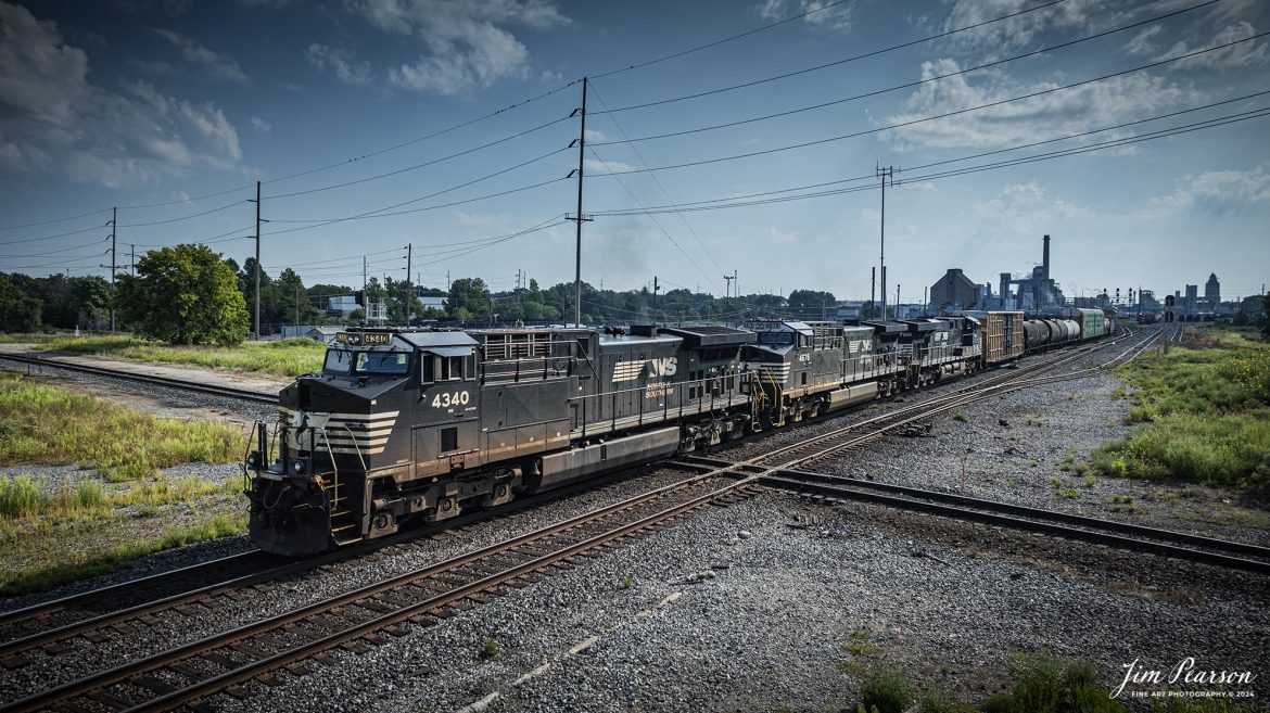 Norfolk Southern 4340 leads a mixed freight westbound as it passes over the WABIC Diamond at Decatur, Illinois on August 24th, 2024, as they head west on the NS Lafayette District. 

The NS RoadRailer trains are now a thing of the past as the last one ran yesterday, 25th of August 2024, and the service has now been discontinued and they will transition fully to standard double-stack trains.

From what I can find on the web: WABIC Junction (Diamond) next to the Wabash Depot Antique Mall in Decatur, Illinois, is where the Norfolk Southern's Springfield-Hannibal/Brooklyn districts and Canadian National's Peoria Subdivision cross. Decatur & Eastern Illinois Railroad also uses the diamond for switching sometimes. 

WABIC is named for the Wabash (WAB) and Illinois Central (IC), which used to cross here back in the good ole days, but times have changed. There were LOTS more tracks back then, along with a tower, and the WAB/Norfolk & Western, Baltimore & Ohio, and IC, as well as the Pennsylvania Railroad crossed here in the past.

Tech Info: DJI Mavic 3 Classic Drone, RAW, 22mm, f/2.8, 1/5000, ISO 170.

#trainphotography #railroadphotography #trains #railways #trainphotographer #railroadphotographer #jimpearsonphotography #NorfolkSouthern #IllinoisRailroads