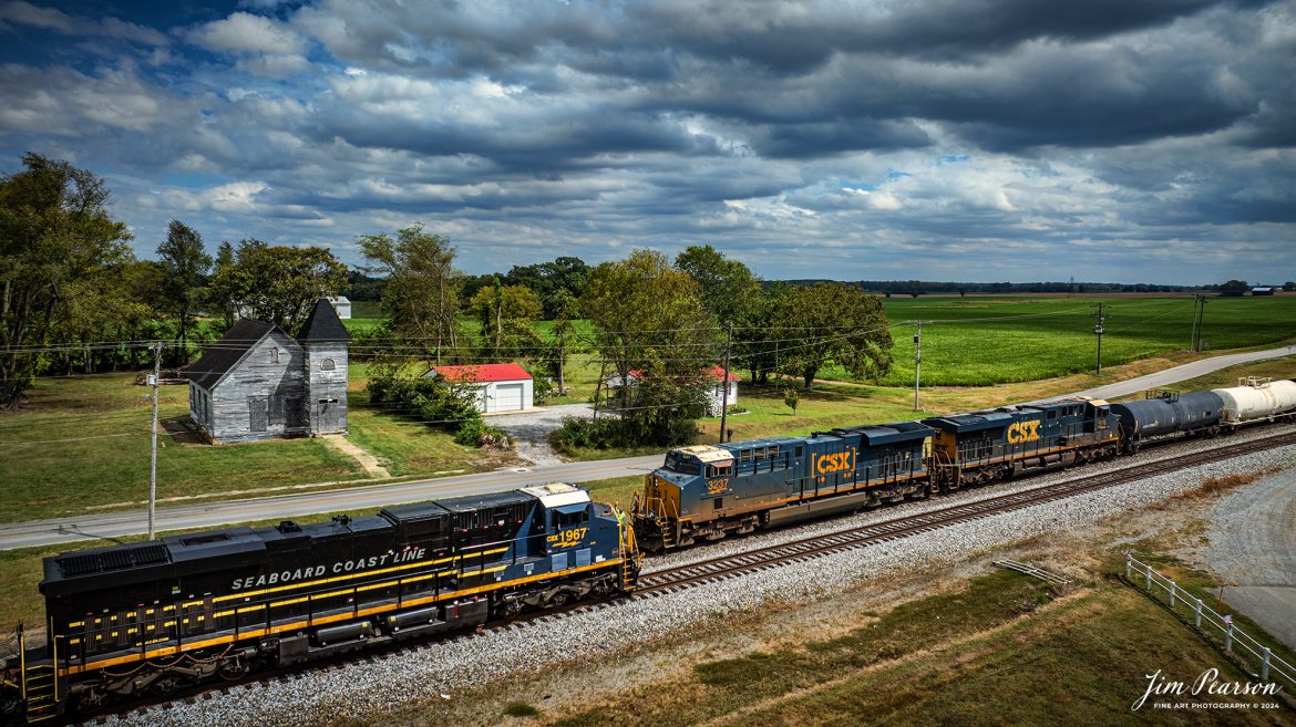 CSX I025 with CSX Seaboard Coast Line Railroad Heritage Unit (SCL), 1967 leading, heads south as it meets M500 in the siding at the north end of Trenton, Kentucky on the CSX Henderson Subdivision, on September 13th, 2024, under stormy skies. 

According to a CSX Press Release: June 6, 2024 - CSX has released a new heritage locomotive, the P&LE 1875, paying tribute to the storied Pittsburgh & Lake Erie Railroad (P&LE). The 15th in CSX’s heritage locomotive series, this new addition to the company’s fleet not only celebrates the rich history of P&LE but also marks a significant milestone in CSX's ongoing commitment to honoring the legacies of America's historic railroads.

The Pittsburgh & Lake Erie Railroad was established in 1875 with a primary mission of transporting essential industrial materials such as coal, coke, iron ore, limestone, and steel among the bustling industrial hubs of the region. 

“It’s mainline connected Pittsburgh, Pennsylvania with Youngstown, Ohio and Connellsville, Pennsylvania. It did not actually reach Lake Erie until 1976,” explained Tim Music, a carman painter at the CSX Waycross Locomotive Shop where the unit was produced.

Despite its relatively modest route mileage, the P&LE Railroad earned the nickname "Little Giant" due to the enormous volume of heavy tonnage it moved. This impressive capability drew significant attention and by 1887, the P&LE became a subsidiary of the dominant New York Central Railroad. Under this new ownership, the P&LE enjoyed substantial improvements to its tracks and added capacity for passenger services, further enhancing its regional significance.

Over time, P&LE expanded by leasing branches from smaller railroads. These extensions included lines southeast along the Monongahela River through Homestead and McKeesport, and along the Youghiogheny River to Connellsville, where it connected with the Western Maryland Railway.

Tech Info: DJI Mavic 3 Classic Drone, RAW, 22mm, f/2.8, 1/2000, ISO 230.

#railroad #railroads #train, #trains #railway #railway #steamtrains #railtransport #railroadengines #picturesoftrains #picturesofrailways #besttrainphotograph #bestphoto #photographyoftrains #steamtrainphotography #CSXPLEheritageunit #bestsoldpicture #JimPearsonPhotography #csxheritagelocomotive #onecsx