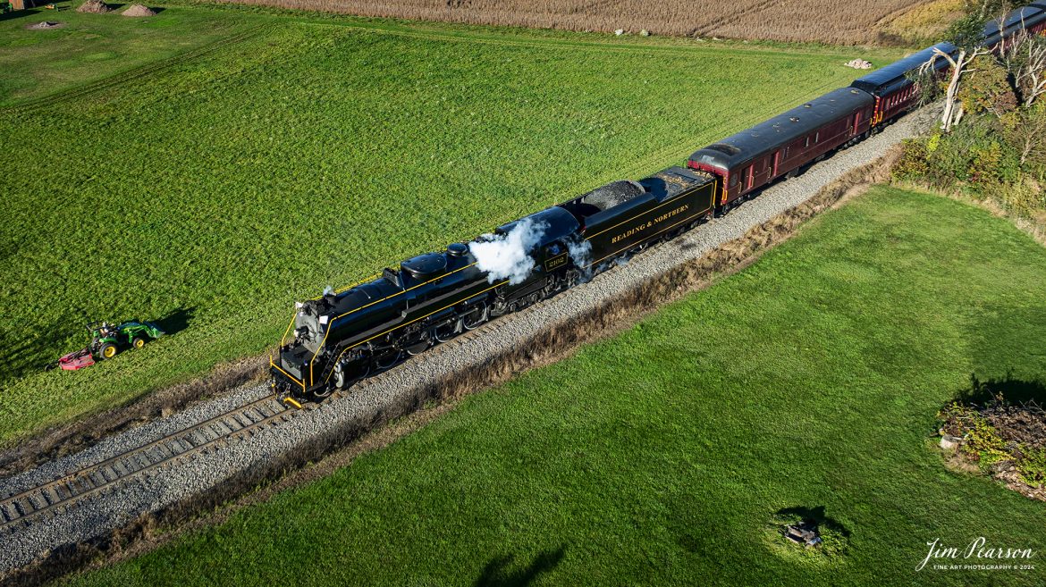 Reading Blue Northern Railroad steam locomotive 2102 passes a farmer mowing his grass as they approach the Church Road crossing at Barnesville on their way to Jim Thorpe, Pennsylvania, on October 5th, 2024.

According to their website: The Reading Company T-1 class #2102 was built in the Reading’s own locomotive shops in 1945. With drivers of 70” diameter, it weighs 404 tons, and its tender holds up to 26 tons of coal, and up to 19,000 gallons of water. After the Reading Steam era was over, the Reading Company used 2102 for the Reading Rambles on several different excursions. The 2102 has had many different owners since it was retired by the Reading Railroad. It is one of only four to survive. The other remaining locomotives are the 2100, 2101, and 2124.

The Blue Mountain and Reading Railroad purchased the 2102 in 1987, and it ran on the Temple to South Hamburg line into the early 1990’s. Once the Blue Mountain and Reading Railroad became the Reading Blue Mountain & Northern, the 2102 ran over Reading & Northern’s rails for a short time before it was removed from service in the early 1990’s. 

In 2022, steam locomotive 2102 reentered service on the Reading & Northern. The locomotive has been used actively to pull both passenger excursions and revenue freight trains.

Tech Info: DJI Mavic 3 Classic Drone, RAW, 24mm, f/2.8, 1/500, ISO 100.

#railroad #railroads #train, #trains #railway #railway #steamtrains #railtransport #railroadengines #picturesoftrains #picturesofrailways #besttrainphotograph #bestphoto #photographyoftrains #bestsoldpicture #JimPearsonPhotography #trainsfromadrone #readingbluenorthernrailroad