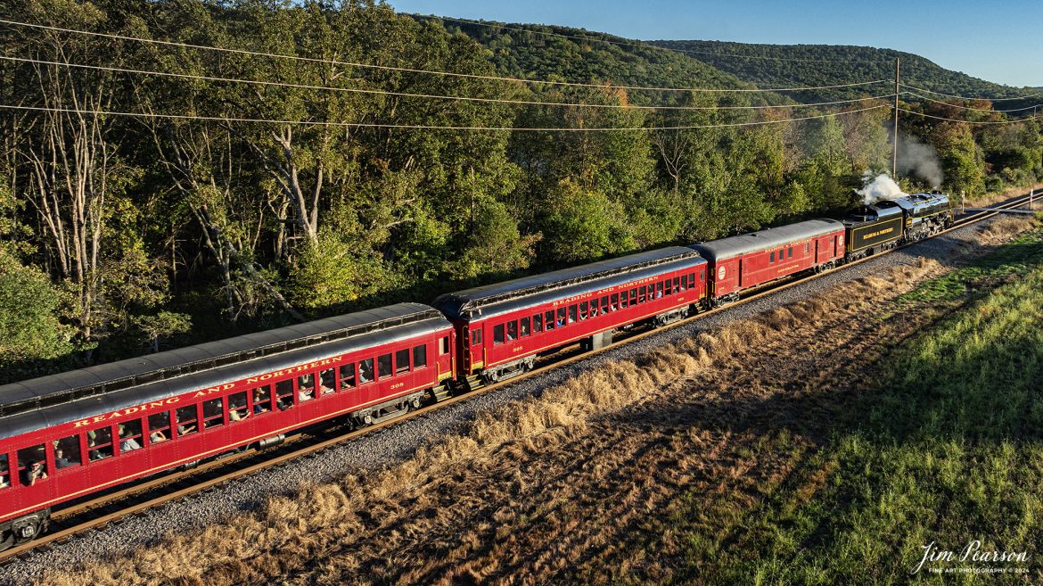 Reading Blue Northern Railroad steam locomotive 2102 leads a passenger train as it approaches a crossing at Molino, Pennsylvania, on October 5th, 2024 as they head for Jim Thorpe during one of their fall excursions.

According to their website: The Reading Company T-1 class #2102 was built in the Reading’s own locomotive shops in 1945. With drivers of 70” diameter, it weighs 404 tons, and its tender holds up to 26 tons of coal, and up to 19,000 gallons of water. After the Reading Steam era was over, the Reading Company used 2102 for the Reading Rambles on several different excursions. The 2102 has had many different owners since it was retired by the Reading Railroad. It is one of only four to survive. The other remaining locomotives are the 2100, 2101, and 2124.

The Blue Mountain and Reading Railroad purchased the 2102 in 1987, and it ran on the Temple to South Hamburg line into the early 1990’s. Once the Blue Mountain and Reading Railroad became the Reading Blue Mountain & Northern, the 2102 ran over Reading & Northern’s rails for a short time before it was removed from service in the early 1990’s. 

In 2022, steam locomotive 2102 reentered service on the Reading & Northern. The locomotive has been used actively to pull both passenger excursions and revenue freight trains.

Tech Info: DJI Mavic 3 Classic Drone, RAW, 24mm, f/2.8, 1/800, ISO 200.

#railroad #railroads #train, #trains #railway #railway #steamtrains #railtransport #railroadengines #picturesoftrains #picturesofrailways #besttrainphotograph #bestphoto #photographyoftrains #bestsoldpicture #JimPearsonPhotography #trainsfromadrone #readingbluenorthernrailroad