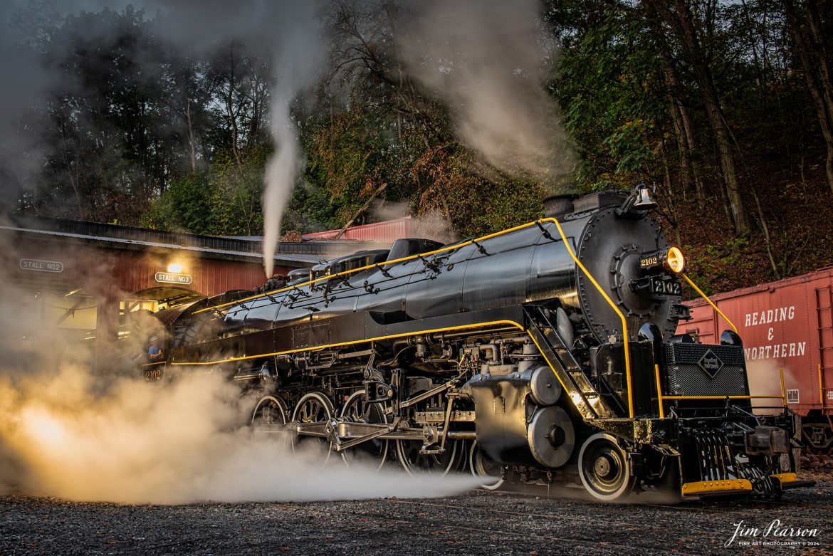 Reading Blue Mountain & Northern Railroad steam locomotive 2102 sits outside the engine house as dawn begins at Port Clinton, Pennsylvania on October 5th, 2024, as it waits to begin its first day of the year of pulling Fall Foliage Excursions.

According to their website: The Reading Company T-1 class #2102 was built in the Reading’s own locomotive shops in 1945. With drivers of 70” diameter, it weighs 404 tons, and its tender holds up to 26 tons of coal, and up to 19,000 gallons of water. After the Reading Steam era was over, the Reading Company used 2102 for the Reading Rambles on several different excursions. The 2102 has had many different owners since it was retired by the Reading Railroad. It is one of only four to survive. The other remaining locomotives are the 2100, 2101, and 2124.

The Blue Mountain and Reading Railroad purchased the 2102 in 1987, and it ran on the Temple to South Hamburg line into the early 1990’s. Once the Blue Mountain and Reading Railroad became the Reading Blue Mountain & Northern, the 2102 ran over Reading & Northern’s rails for a short time before it was removed from service in the early 1990’s. 

In 2022, steam locomotive 2102 reentered service on the Reading & Northern. The locomotive has been used actively to pull both passenger excursions and revenue freight trains.

Tech Info: Nikon D810, RAW, Nikon 24-70 @ 31mm, 5.6, 1/2 second, ISO 200.

#railroad #railroads #train, #trains #railway #railway #steamtrains #railtransport #railroadengines #picturesoftrains #picturesofrailways #besttrainphotograph #bestphoto #photographyoftrains #bestsoldpicture #JimPearsonPhotography #RBNRR