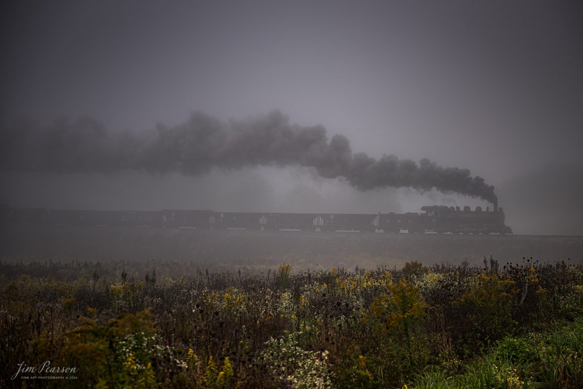 East Broad Top (EBT) steam locomotive #16 pulls a mixed freight through the early morning fog as they head out of Rockhill Furnace, Pennsylvania on October 5th, 2024, during the museum’s Friends of the East Broad top event.

According to the East Broad Top Website: Locomotive #16 was built in 1916 by the Baldwin Locomotive Works.

Entering the age of modern steam in 1916, the EBT received its first of three large Mikados. Unlike the previous three smaller locomotives, #16 came with superheaters, piston valves, and Southern valve gear. One story mentions #16 pulled 60 empty hoppers from Mt. Union to Rockhill in one train, literally clearing out the yard. #16 underwent an overhaul in 1955 and made only a handful of trips in early 1956 before the railroad shut down an overhaul when the EBT shut down. On February 1, 2023, the locomotive returned to service.

Tech Info: DJI Mavic 3 Classic Drone, RAW, 24mm, f/2.8, 1/400, ISO 80.

#railroad #railroads #train, #trains #railway #railway #steamtrains #railtransport #railroadengines #picturesoftrains #picturesofrailways #besttrainphotograph #bestphoto #photographyoftrains #bestsoldpicture #JimPearsonPhotography #trainsfromtheair #trainsfromadrone #EastBroadTop