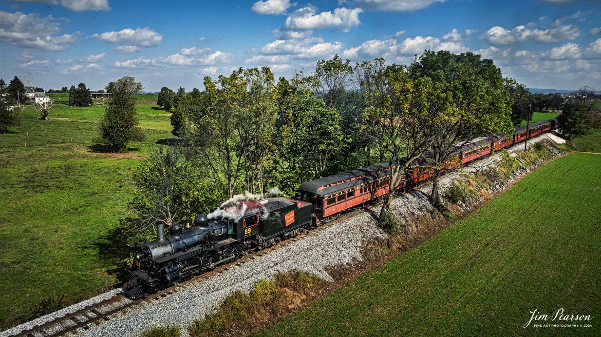 Canadian National 89 pulls a passenger train through the countryside on the Strasburg Railroad as It heads back to the depot at Strasburg, PA, on October 7th, 2024.

According to Wikipedia: The Strasburg Rail Road (reporting mark SRC) is a heritage railroad and the oldest continuously operating standard-gauge railroad in the western hemisphere, as well as the oldest public utility in the Commonwealth of Pennsylvania. Chartered in 1832, the Strasburg Rail Road Company is today a heritage railroad offering excursion trains hauled by steam locomotives on 4.02 mi of track in Pennsylvania Dutch Country, as well as providing contract railroad mechanical services, and freight service to area shippers. The railroad's headquarters are outside Strasburg, Pennsylvania.

Tech Info: DJI Mavic 3 Classic Drone, RAW, 24mm, f/2.8, 1/1600, ISO 100.

#photographyoftrains #bestsoldpicture #JimPearsonPhotography #StrasburgRailroad