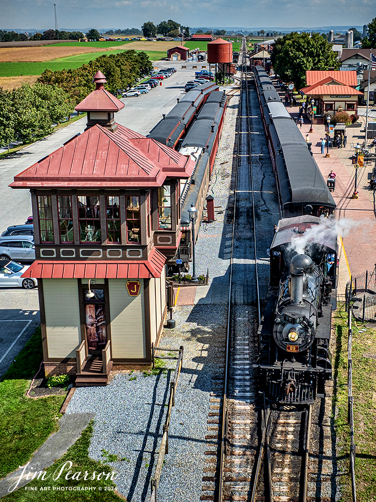 Canadian National 89 pulls from its passenger train at the Strasburg Railroad Depot to run around the train in preparation for another departure from the depot at Ronks, PA, on October 7th, 2024.

According to Wikipedia: The Strasburg Rail Road (reporting mark SRC) is a heritage railroad and the oldest continuously operating standard-gauge railroad in the western hemisphere, as well as the oldest public utility in the Commonwealth of Pennsylvania. Chartered in 1832, the Strasburg Rail Road Company is today a heritage railroad offering excursion trains hauled by steam locomotives on 4.02 mi of track in Pennsylvania Dutch Country, as well as providing contract railroad mechanical services, and freight service to area shippers. The railroad's headquarters are outside Strasburg, Pennsylvania.

Tech Info: DJI Mavic 3 Classic Drone, RAW, 24mm, f/2.8, 1/1600, ISO 100.

#photographyoftrains #bestsoldpicture #JimPearsonPhotography #StrasburgRailroad