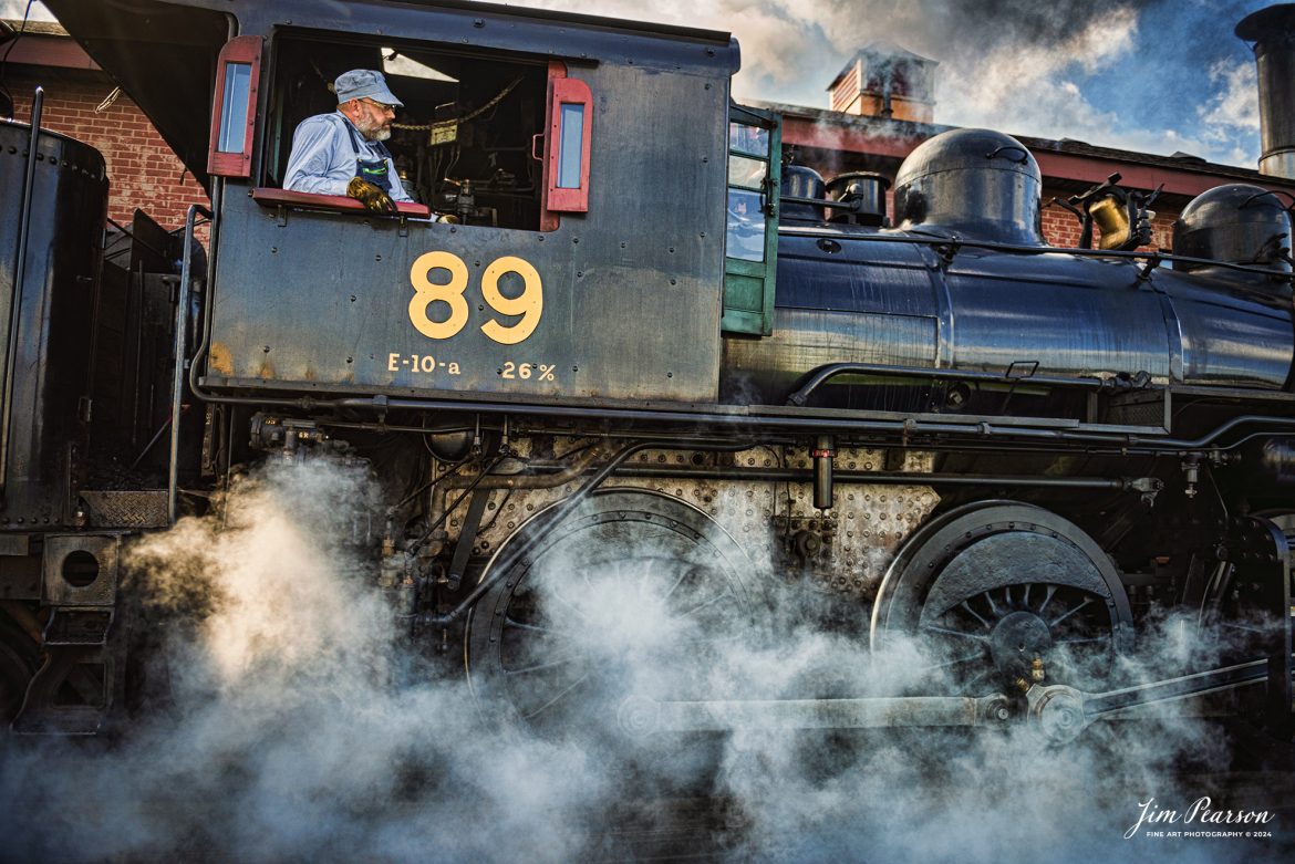 Engineer Mark Young keeps an watchful eye on the track ahead of Canadian National 89 as he pulls past the engine house at the Strasburg Railroad as he prepares to hook up to the first train of the day on October 7th, 2024, at Strasburg, Pennsylvania.

According to Wikipedia: The Strasburg Rail Road (reporting mark SRC) is a heritage railroad and the oldest continuously operating standard-gauge railroad in the western hemisphere, as well as the oldest public utility in the Commonwealth of Pennsylvania. Chartered in 1832, the Strasburg Rail Road Company is today a heritage railroad offering excursion trains hauled by steam locomotives on 4.02 mi of track in Pennsylvania Dutch Country, as well as providing contract railroad mechanical services, and freight service to area shippers. The railroad's headquarters are at Strasburg, Pennsylvania.

Tech Info: Nikon D810, RAW, Nikon 24-70 @ 24mm, 2.8, 1/1600, ISO 220.

#railroad #railroads #train, #trains #railway #railway #steamtrains #railtransport #railroadengines #picturesoftrains #picturesofrailways #besttrainphotograph #bestphoto #photographyoftrains #bestsoldpicture #JimPearsonPhotography #StrasburgRailroad