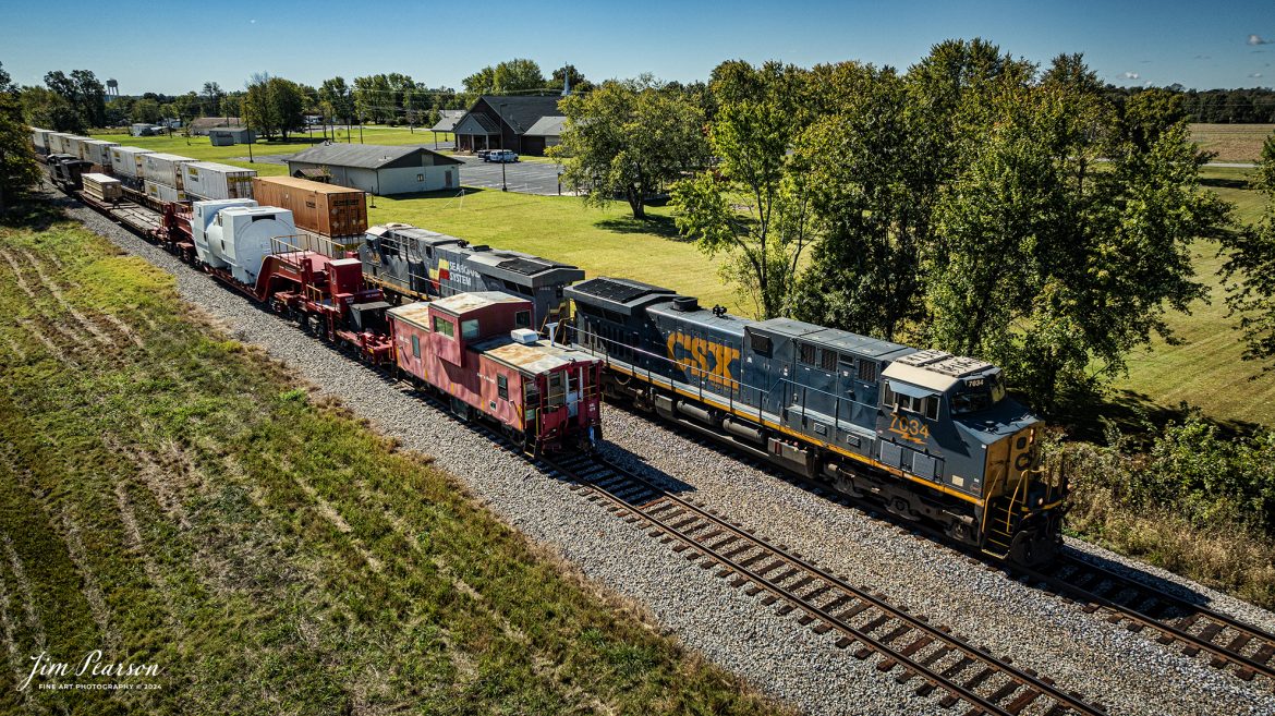 CSXT 85 leads S991 as they wait in the siding for CSX I128 with the Seaboard System Heritage Unit trailing second to pass them at the north end of Crofton, Ky, on October 16th, 2024, on the CSX Henderson Subdivision. CSX S991 has a depressed flatbed with an oversized load traveling on KRL 204041, a Schnabel car with Red and Ready KRL 073 caboose trailing.  

According to Wikipedia: A Schnabel car or Schnabel wagon is a specialized type of railroad freight car. It is designed to carry heavy and oversized loads in such a way that the load makes up part of the car. The load is suspended between the two ends of the cars by lifting arms; the lifting arms are connected to an assembly of span bolsters that distribute the weight of the load and the lifting arm over many wheels.

When a Schnabel car is empty, the two lifting arms are connected to one another and the car can usually operate at normal freight train speeds. Some Schnabel cars include hydraulic equipment that will either lift or horizontally shift the load while in transit (at very low speeds) to clear obstructions along the car's route. 

That is the case with this car as there was a crew on the caboose that shifted the load whenever necessary on meets or areas with close clearance. It was traveling at 25 mph on the mains and much slower through turnouts and switches.

Tech Info: DJI Mavic 3 Classic Drone, RAW, 22mm, f/2.8, 1/2500, ISO 140.

#trainphotography #jimpearsonphotography #trending #csxt #bestsoldphotos