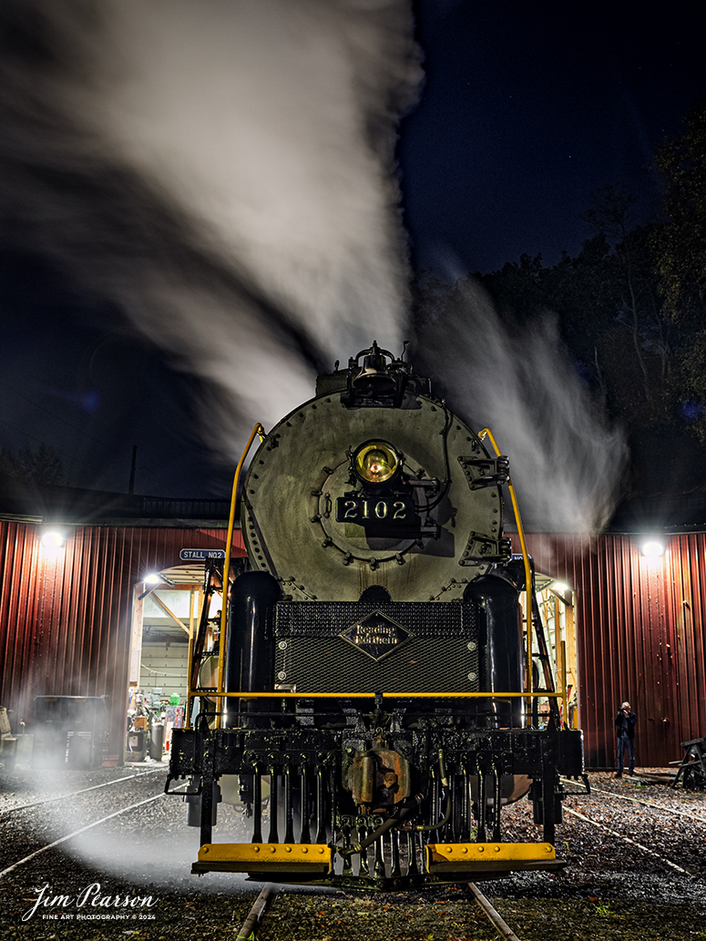 70300Reading Blue Mountain & Northern Railroad steam locomotive 2102 sits outside the engine house as dawn begins at Port Clinton, Pennsylvania on October 5th, 2024, as it waits to begin its first day of the year of pulling Fall Foliage Excursions.

According to their website: The Reading Company T-1 class #2102 was built in the Reading’s own locomotive shops in 1945. With drivers of 70” diameter, it weighs 404 tons, and its tender holds up to 26 tons of coal, and up to 19,000 gallons of water. After the Reading Steam era was over, the Reading Company used 2102 for the Reading Rambles on several different excursions. The 2102 has had many different owners since it was retired by the Reading Railroad. It is one of only four to survive. The other remaining locomotives are the 2100, 2101, and 2124.

The Blue Mountain and Reading Railroad purchased the 2102 in 1987, and it ran on the Temple to South Hamburg line into the early 1990’s. Once the Blue Mountain and Reading Railroad became the Reading Blue Mountain & Northern, the 2102 ran over Reading & Northern’s rails for a short time before it was removed from service in the early 1990’s. 

In 2022, steam locomotive 2102 reentered service on the Reading & Northern. The locomotive has been used actively to pull both passenger excursions and revenue freight trains.

Tech Info: Nikon D810, RAW, Nikon 24-70 @ 24mm, f/5.6, 2.5 seconds, ISO 200.

#railroad #railroads #train, #trains #railway #railway #steamtrains #railtransport #railroadengines #picturesoftrains #picturesofrailways #besttrainphotograph #bestphoto #photographyoftrains #bestsoldpicture #JimPearsonPhotography #RBNRR