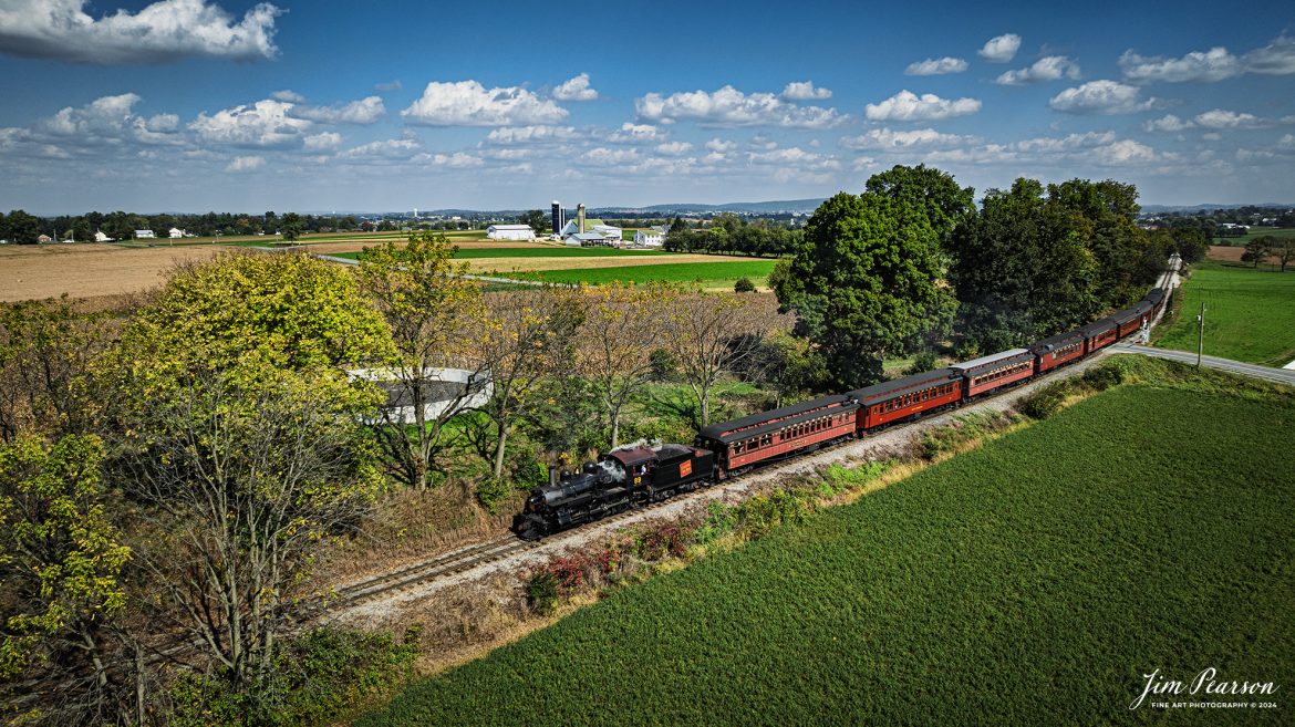 Canadian National 89 pulls a passenger train through the countryside on the Strasburg Railroad as It heads back to the depot at Strasburg, PA, on October 7th, 2024.

According to Wikipedia: The Strasburg Rail Road (reporting mark SRC) is a heritage railroad and the oldest continuously operating standard-gauge railroad in the western hemisphere, as well as the oldest public utility in the Commonwealth of Pennsylvania. Chartered in 1832, the Strasburg Rail Road Company is today a heritage railroad offering excursion trains hauled by steam locomotives on 4.02 mi of track in Pennsylvania Dutch Country, as well as providing contract railroad mechanical services, and freight service to area shippers. The railroad's headquarters are outside Strasburg, Pennsylvania.

Tech Info: DJI Mavic 3 Classic Drone, RAW, 24mm, f/2.8, 1/1600, ISO 100.

#photographyoftrains #bestsoldpicture #JimPearsonPhotography #StrasburgRailroad