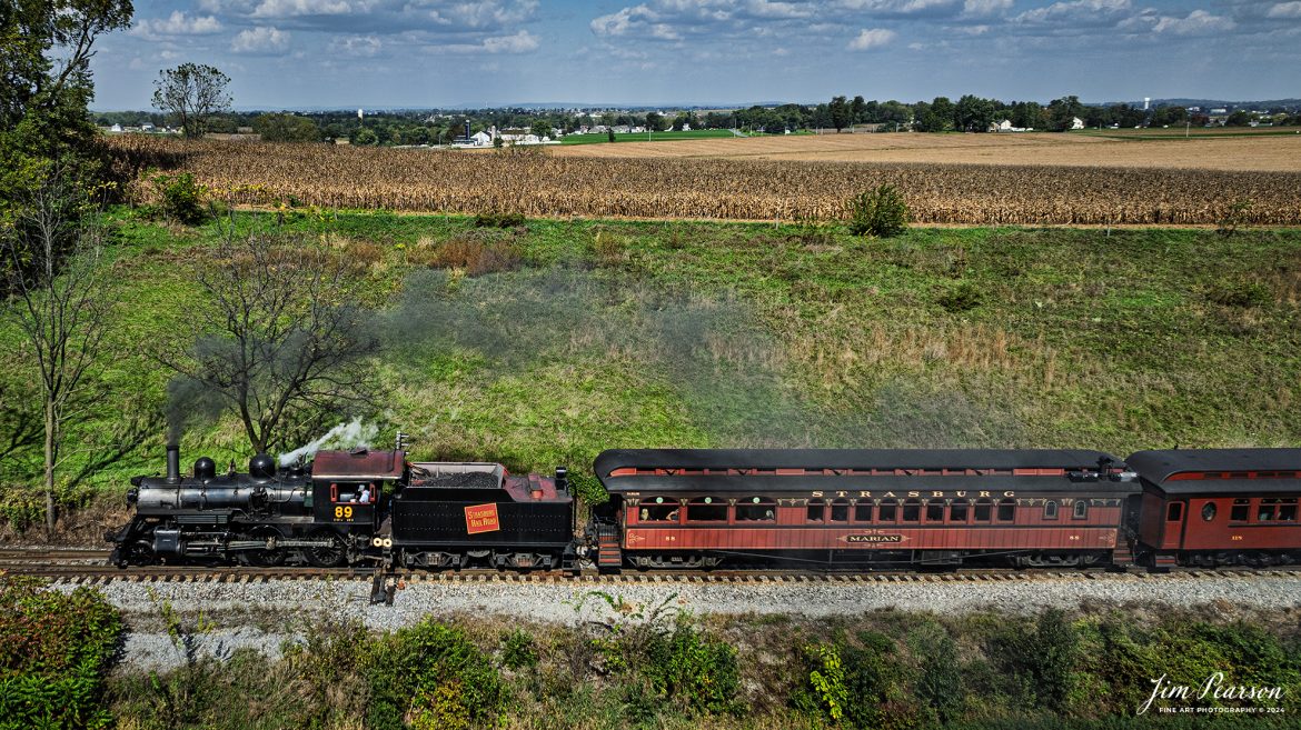 Canadian National 89 pulls a passenger train through the countryside on the Strasburg Railroad as It heads back to the depot at Strasburg, PA, on October 7th, 2024.

According to Wikipedia: The Strasburg Rail Road (reporting mark SRC) is a heritage railroad and the oldest continuously operating standard-gauge railroad in the western hemisphere, as well as the oldest public utility in the Commonwealth of Pennsylvania. Chartered in 1832, the Strasburg Rail Road Company is today a heritage railroad offering excursion trains hauled by steam locomotives on 4.02 mi of track in Pennsylvania Dutch Country, as well as providing contract railroad mechanical services, and freight service to area shippers. The railroad's headquarters are outside Strasburg, Pennsylvania.

Tech Info: DJI Mavic 3 Classic Drone, RAW, 24mm, f/2.8, 1/1600, ISO 100.

#photographyoftrains #bestsoldpicture #JimPearsonPhotography #StrasburgRailroad