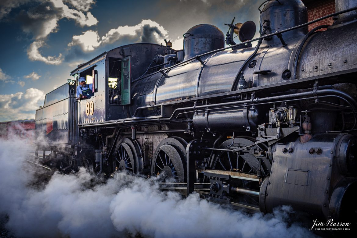 Engineer Mark Young keeps an watchful eye on the track ahead of Canadian National 89 as he pulls past the engine house at the Strasburg Railroad as he prepares to hook up to the first train of the day on October 7th, 2024, at Strasburg, Pennsylvania.

According to Wikipedia: The Strasburg Rail Road (reporting mark SRC) is a heritage railroad and the oldest continuously operating standard-gauge railroad in the western hemisphere, as well as the oldest public utility in the Commonwealth of Pennsylvania. Chartered in 1832, the Strasburg Rail Road Company is today a heritage railroad offering excursion trains hauled by steam locomotives on 4.02 mi of track in Pennsylvania Dutch Country, as well as providing contract railroad mechanical services, and freight service to area shippers. The railroad's headquarters are at Strasburg, Pennsylvania.

Tech Info: Nikon D810, RAW, Nikon 24-70 @ 29mm, 2.8, 1/1600, ISO 250.

#railroad #railroads #train, #trains #railway #railway #steamtrains #railtransport #railroadengines #picturesoftrains #picturesofrailways #besttrainphotograph #bestphoto #photographyoftrains #bestsoldpicture #JimPearsonPhotography #StrasburgRailroad