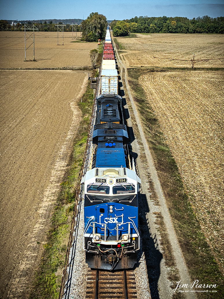 CSX I025 sits at the beginning of the viaduct that passes over the flood plain leading up to the bridge at Henderson, Ky that crosses over the Ohio River with the CSXT Pride in Service Honoring Our Law Enforcement unit leading on October 26th, 2024. 

The train was held up for about 2 hours as members of the Henderson Fire Department finished putting out a tie fire on the bridge that spans the river on the CSX Henderson Subdivision at Henderson, Kentucky; fortunately, except for the ties, the bridge is made out of steel.

CSXT 3194 is painted primarily in black, blue and white, with the slogans “To Protect and Serve” and “Honoring Our Law Enforcement.” It also prominently features the CSX Transportation Railroad Police logo, as well as police, fire and emergency responder logos.

Tech Info: DJI Mavic 3 Classic Drone, RAW, 24mm, f/2.8, 1/2500, ISO 100.

#picturesofrailways #besttrainphotograph #bestphoto #photographyoftrains #bestsoldpicture #JimPearsonPhotography