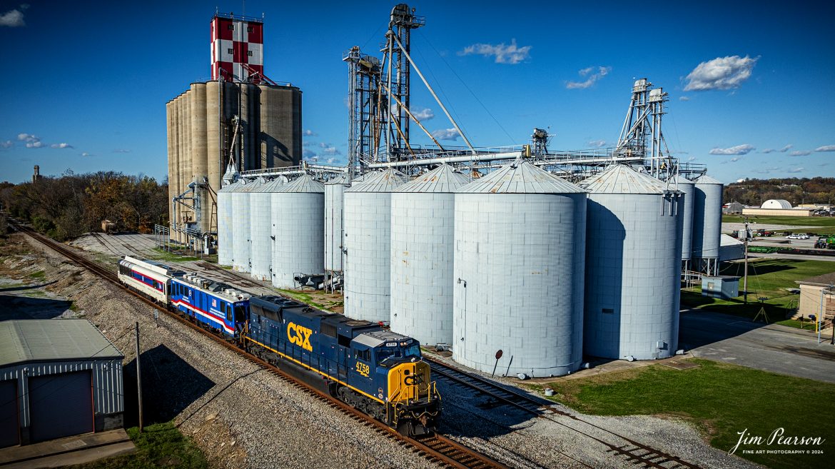 CSXT 4758 leads W008 with two FRA inspection cars, DOTX 218 and DOTX 220 as they pass the grain facility at Hopkinsville, Kentucky on the CSX Henderson Subdivision, on October 20th, 2024. 

From what I can find on the FRA Website, DOTX-218 is a Gage Restraint Measurement Vehicle and DOTX-220 Track Geometry Car. 

DOTX 218 Gage Restraint Measurement System (GRMS) vehicle procured in May 2004, is a state-of-the-art deployable GRMS vehicle which utilizes a 5th split railroad axle to laterally load the head of both adjacent rails of railroad track in order to measure rail motion under a combined vertical and later load for the detection of weak ties and fasteners. It has a unique suspension system which maintains alignment and apply continuous loads perpendicular to the rails regardless of the roll, pitch or vertical movement of the carbody on its suspension, or the curvature of the track; lifts and lowers split axle for testing and stowage; and orients split axle so that wheels are tangent to rails as track curvature varies.

DOTX 220 measures track geometry parameters, i.e., track gage, alignment, track surface (cross level, warp, profile) and calculate limiting train speed in curves. Fully equipped with non-contact sensors, the TGMS computes track geometry parameters at speeds of up to 125 miles per hour. Data can be processed to 200 miles per hour.

Tech Info: DJI Mavic 3 Classic Drone, RAW, 24mm, f/5, 1/3200, ISO 100.

#besttrainphotograph #bestphoto #photographyoftrains #bestsoldpicture #JimPearsonPhotography