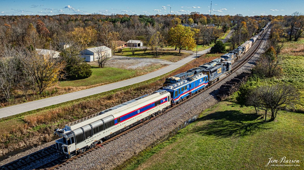 CSXT 4758 leads W008 with two FRA inspection cars, DOTX 218 and DOTX 220 as they meet M500 waiting in the siding at the north end of Kelly, Kentucky on the CSX Henderson Subdivision, on October 20th, 2024. 

From what I can find on the FRA Website, DOTX-218 is a Gage Restraint Measurement Vehicle and DOTX-220 Track Geometry Car. 

DOTX 218 Gage Restraint Measurement System (GRMS) vehicle procured in May 2004, is a state-of-the-art deployable GRMS vehicle which utilizes a 5th split railroad axle to laterally load the head of both adjacent rails of railroad track in order to measure rail motion under a combined vertical and later load for the detection of weak ties and fasteners. It has a unique suspension system which maintains alignment and apply continuous loads perpendicular to the rails regardless of the roll, pitch or vertical movement of the carbody on its suspension, or the curvature of the track; lifts and lowers split axle for testing and stowage; and orients split axle so that wheels are tangent to rails as track curvature varies.

DOTX 220 measures track geometry parameters, i.e., track gage, alignment, track surface (cross level, warp, profile) and calculate limiting train speed in curves. Fully equipped with non-contact sensors, the TGMS computes track geometry parameters at speeds of up to 125 miles per hour. Data can be processed to 200 miles per hour.

Tech Info: DJI Mavic 3 Classic Drone, RAW, 24mm, f/5, 1/2500, ISO 150.

#besttrainphotograph #bestphoto #photographyoftrains #bestsoldpicture #JimPearsonPhotography