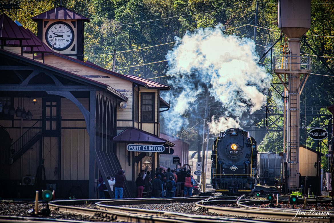 Passengers crowd the depot at Port Clinton, PA as Reading Blue Mountain & Northern Railroad steam locomotive 2102 arrives at the station at Port Clinton, Pennsylvania on October 5th, 2024,during its first day of the year of pulling Fall Foliage Excursions.

According to their website: The Reading Company T-1 class #2102 was built in the Reading’s own locomotive shops in 1945. With drivers of 70” diameter, it weighs 404 tons, and its tender holds up to 26 tons of coal, and up to 19,000 gallons of water. After the Reading Steam era was over, the Reading Company used 2102 for the Reading Rambles on several different excursions. The 2102 has had many different owners since it was retired by the Reading Railroad. It is one of only four to survive. The other remaining locomotives are the 2100, 2101, and 2124.

The Blue Mountain and Reading Railroad purchased the 2102 in 1987, and it ran on the Temple to South Hamburg line into the early 1990’s. Once the Blue Mountain and Reading Railroad became the Reading Blue Mountain & Northern, the 2102 ran over Reading & Northern’s rails for a short time before it was removed from service in the early 1990’s. 

In 2022, steam locomotive 2102 reentered service on the Reading & Northern. The locomotive has been used actively to pull both passenger excursions and revenue freight trains.

Tech Info: Nikon D810, RAW, Nikon 70-300 @ 300mm, f/5.6, 1640, ISO 360.

#steamtrains #besttrainphotograph #JimPearsonPhotography #RBNRR