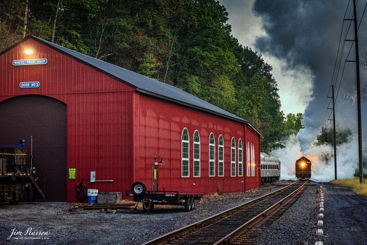 Reading Blue Mountain & Northern Railroad steam locomotive 2102 prepares to back past the Wheel True Shop, during the early morning light, at Port Clinton, Pennsylvania on October 5th, 2024 as they head to Reading, PA for the first day of the year of pulling Fall Foliage Excursions.

According to their website: The Reading Company T-1 class #2102 was built in the Reading’s own locomotive shops in 1945. With drivers of 70” diameter, it weighs 404 tons, and its tender holds up to 26 tons of coal, and up to 19,000 gallons of water. After the Reading Steam era was over, the Reading Company used 2102 for the Reading Rambles on several different excursions. The 2102 has had many different owners since it was retired by the Reading Railroad. It is one of only four to survive. The other remaining locomotives are the 2100, 2101, and 2124.

The Blue Mountain and Reading Railroad purchased the 2102 in 1987, and it ran on the Temple to South Hamburg line into the early 1990’s. Once the Blue Mountain and Reading Railroad became the Reading Blue Mountain & Northern, the 2102 ran over Reading & Northern’s rails for a short time before it was removed from service in the early 1990’s. 

In 2022, steam locomotive 2102 reentered service on the Reading & Northern. The locomotive has been used actively to pull both passenger excursions and revenue freight trains.

Tech Info: Nikon D810, RAW, Nikon 24-70 @ 70mm, 1/250, f/8, ISO 10,000.

#railroad #railroads #train, #trains #railway #railway #steamtrains #railtransport #railroadengines #picturesoftrains #picturesofrailways #besttrainphotograph #bestphoto #photographyoftrains #bestsoldpicture #JimPearsonPhotography #RBNRR