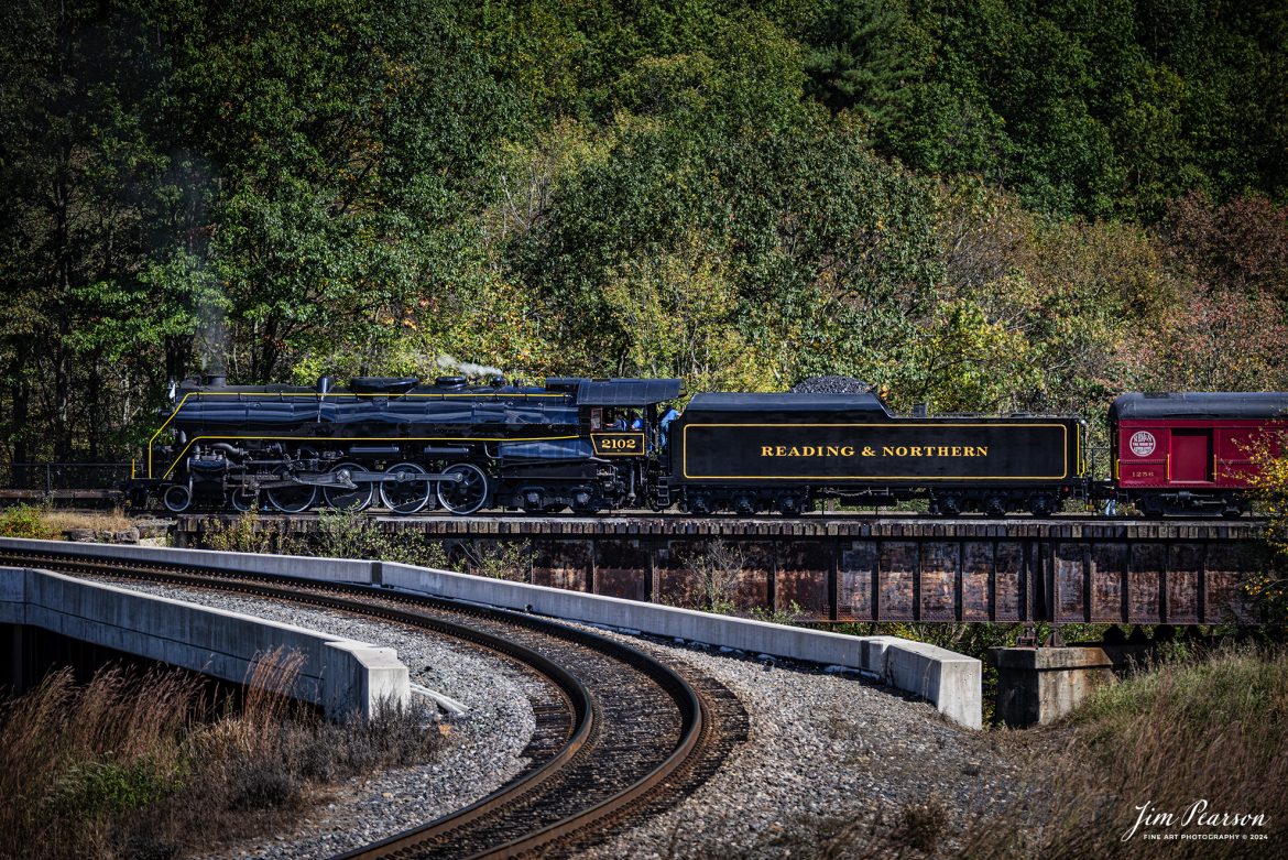 Reading & Northern's 2102 steam locomotive backs their passenger train out of the wye as they finish turning their train just outside of Jim Thorpe, Pennsylvania on October 5th, 2024.

According to their website: The Reading Company T-1 class #2102 was built in the Reading’s own locomotive shops in 1945. With drivers of 70” diameter, it weighs 404 tons, and its tender holds up to 26 tons of coal, and up to 19,000 gallons of water. After the Reading Steam era was over, the Reading Company used 2102 for the Reading Rambles on several different excursions. The 2102 has had many different owners since it was retired by the Reading Railroad. It is one of only four to survive. The other remaining locomotives are the 2100, 2101, and 2124.

The Blue Mountain and Reading Railroad purchased the 2102 in 1987, and it ran on the Temple to South Hamburg line into the early 1990’s. Once the Blue Mountain and Reading Railroad became the Reading Blue Mountain & Northern, the 2102 ran over Reading & Northern’s rails for a short time before it was removed from service in the early 1990’s. 

In 2022, steam locomotive 2102 reentered service on the Reading & Northern. The locomotive has been used actively to pull both passenger excursions and revenue freight trains.

Tech Info: Nikon D810, RAW, Nikon 70-300 @ 165mm, f/5.3, 1/1000, ISO 320.

#steamtrains #besttrainphotograph #JimPearsonPhotography #RBNRR